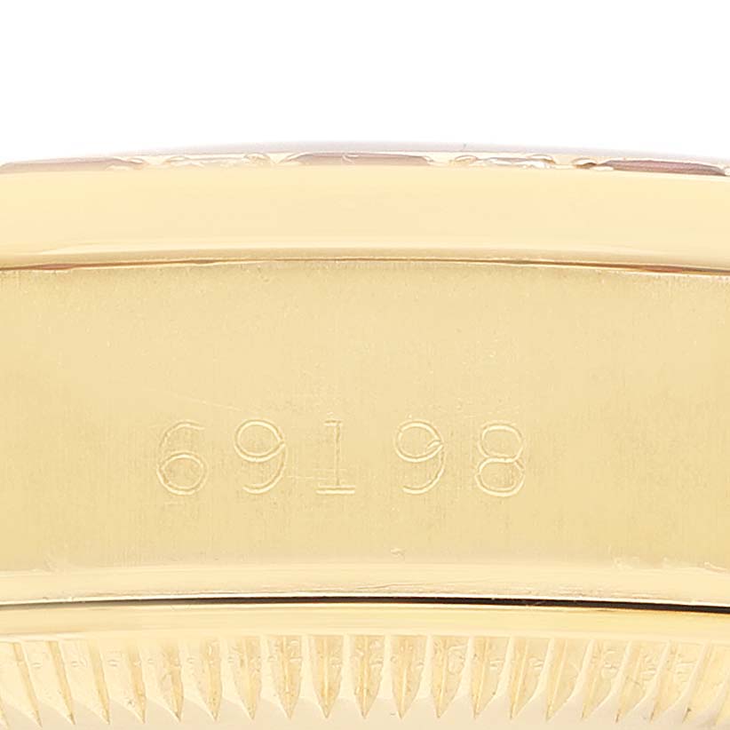 The image shows a close-up of the side of a Rolex President 69198 Women
s Yellow Gold Champagne Dial 69198 Women
s Yellow Gold Champagne Dial model watch, highlighting the case edge and part of the bezel with the model number 69198.