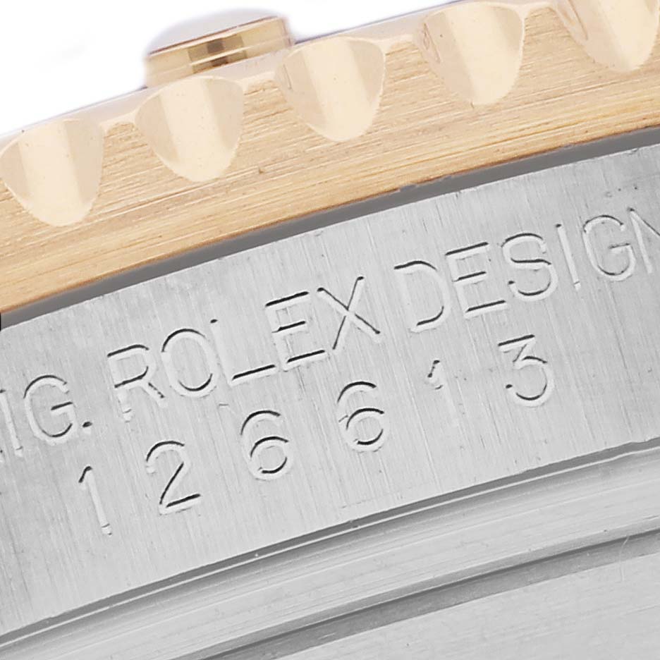 The image shows a close-up of the Rolex Submariner 126613LB Men's Steel and Gold (two tone) Blue Dial 126613LB Men's Steel and Gold (two tone) Blue Dial model's engraved case side and bezel edge.