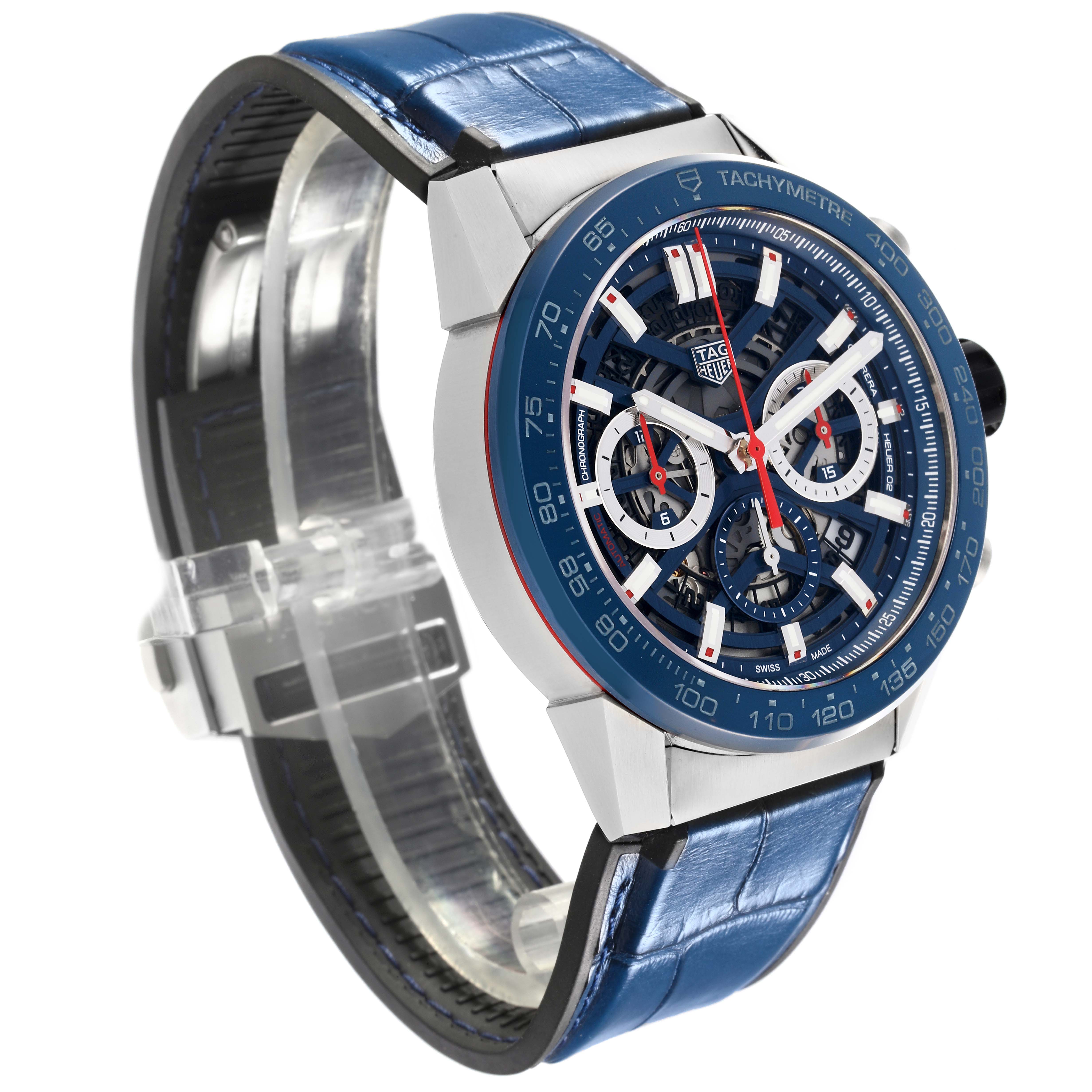 The Carrera model by Tag Heuer is shown in a three-quarter view, highlighting the blue dial, tachymeter, and leather strap.
