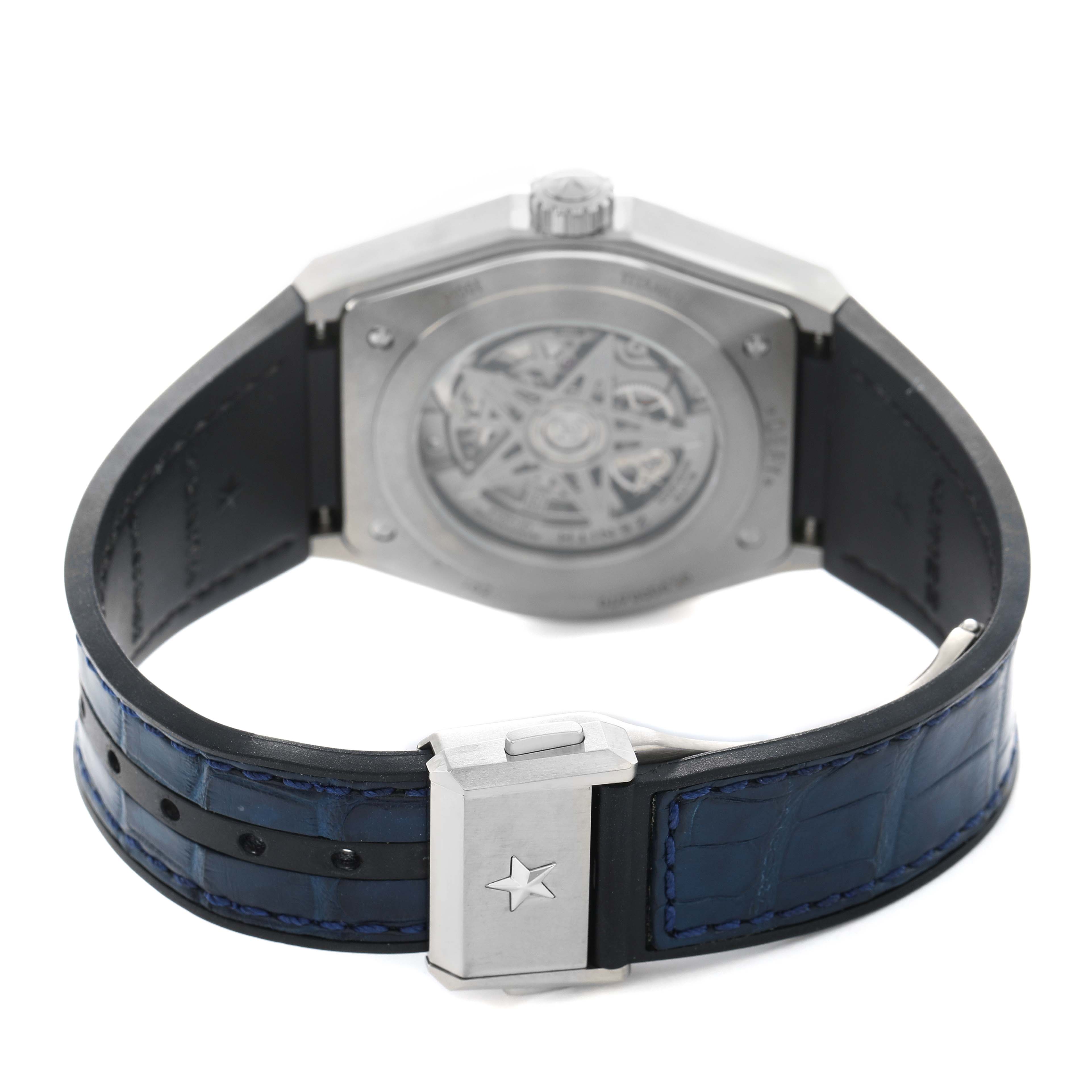 The Zenith Defy 95.9000.670/51 Men's Titanium Blue Dial watch is shown from the back, highlighting the open case back, blue leather strap, and clasp.