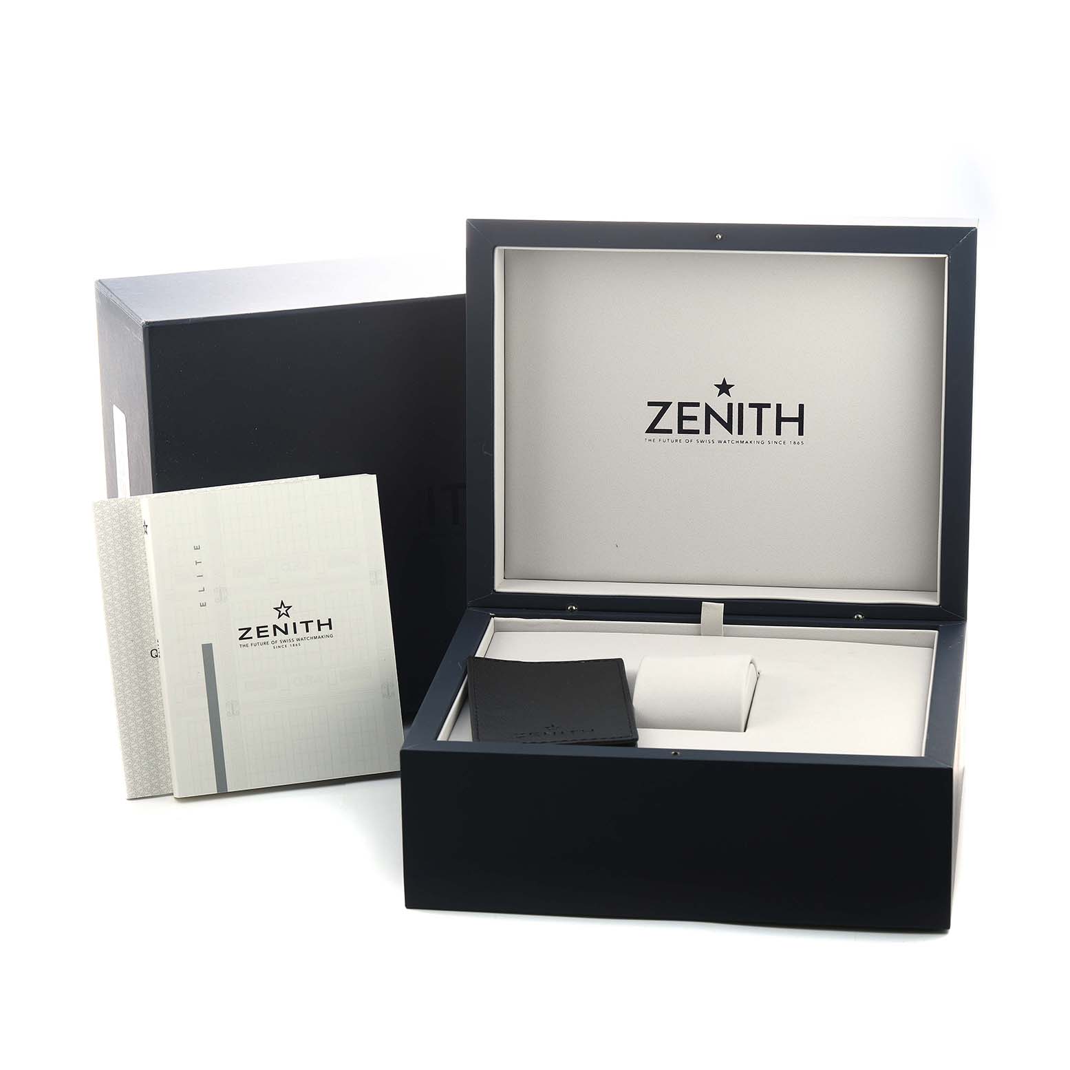 The image shows the packaging and accessories for a Zenith Defy 95.9000.670/51 Men's Titanium Blue Dial model, including the watch box and user manuals.