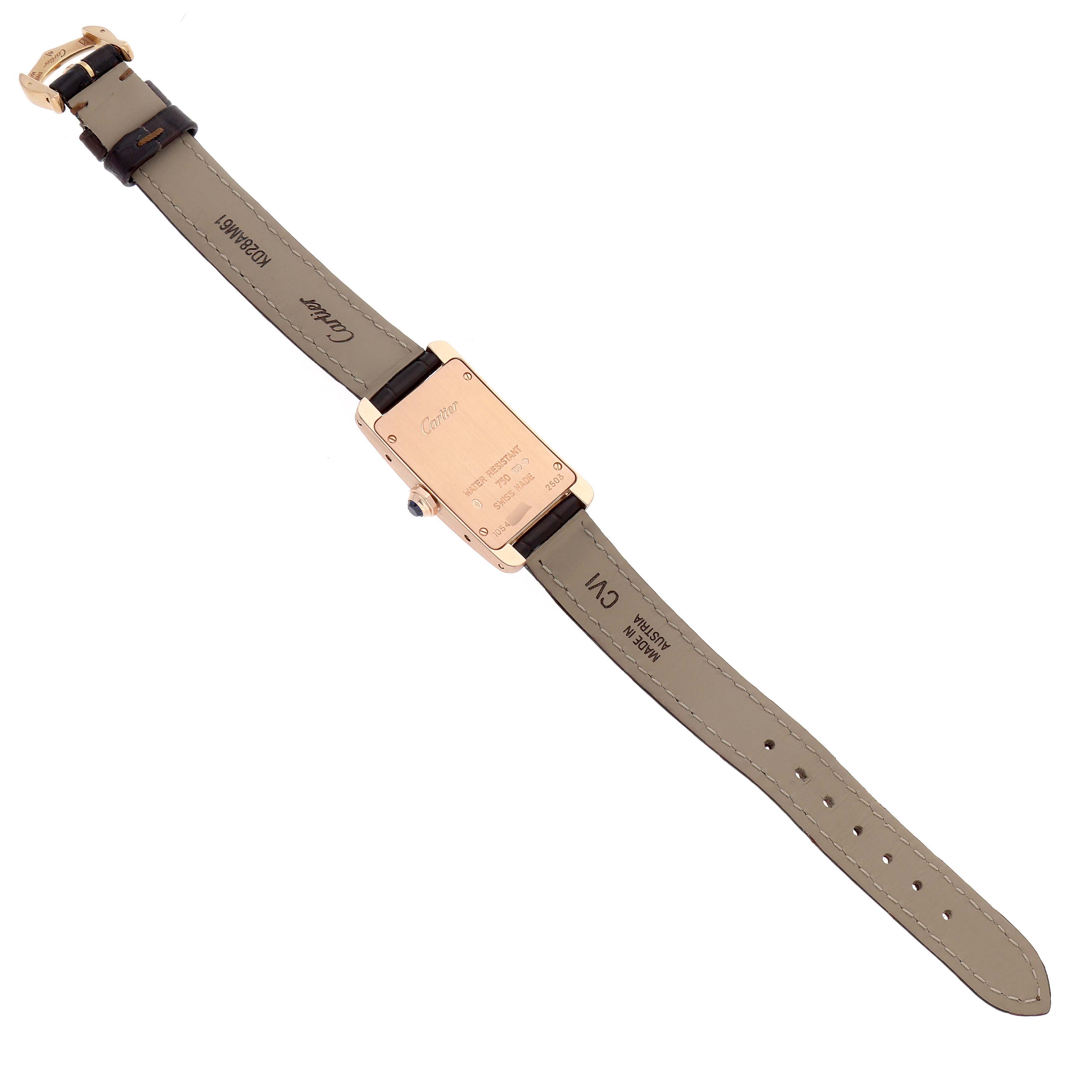 The Cartier Tank Américaine watch is shown from the back, displaying the case back, straps, and buckle.