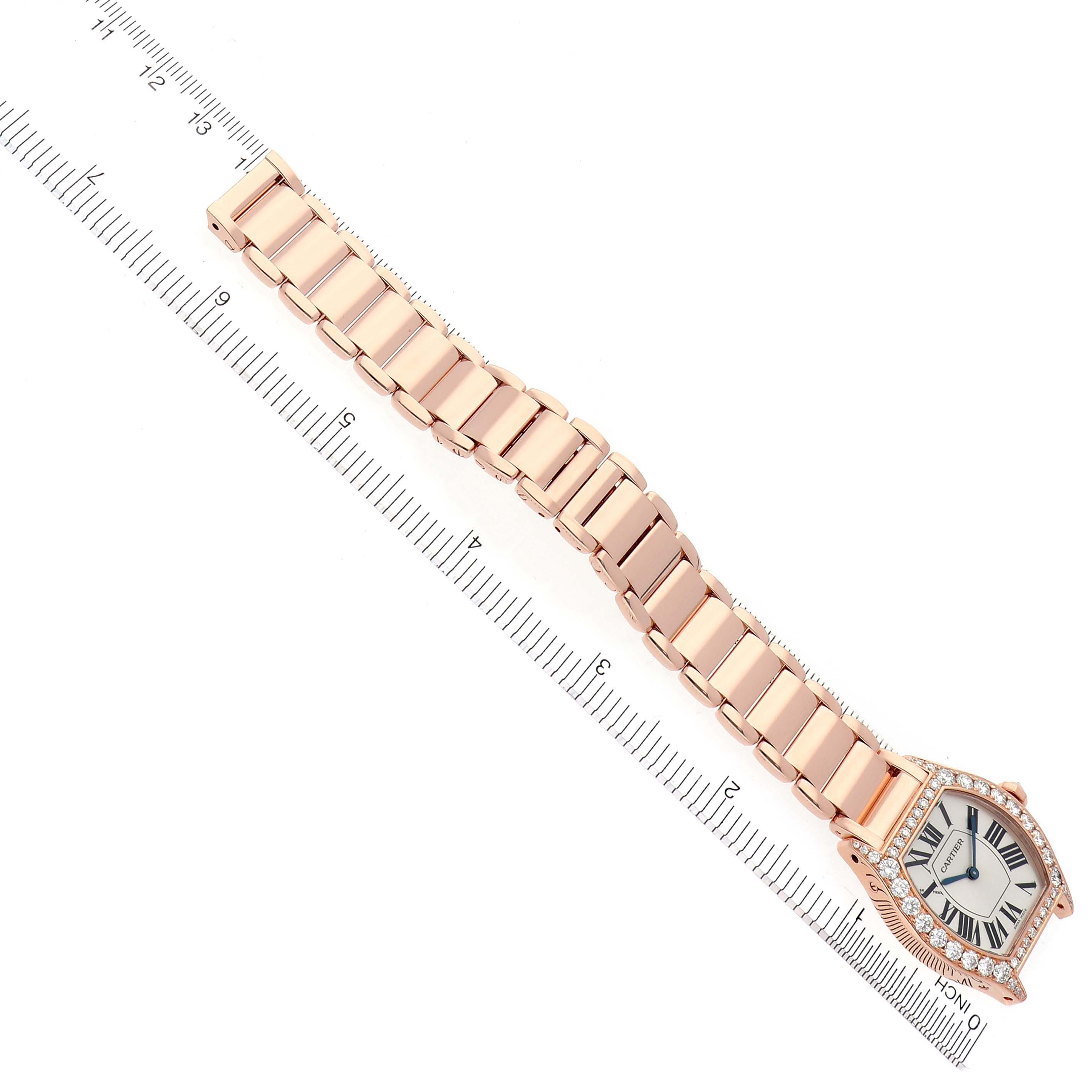 The Cartier Tortue 66195 Women's Rose Gold Silver Dial 66195 Women's Rose Gold Silver Dial watch is shown from a top-down angle with the face and full bracelet visible alongside a ruler for scale.