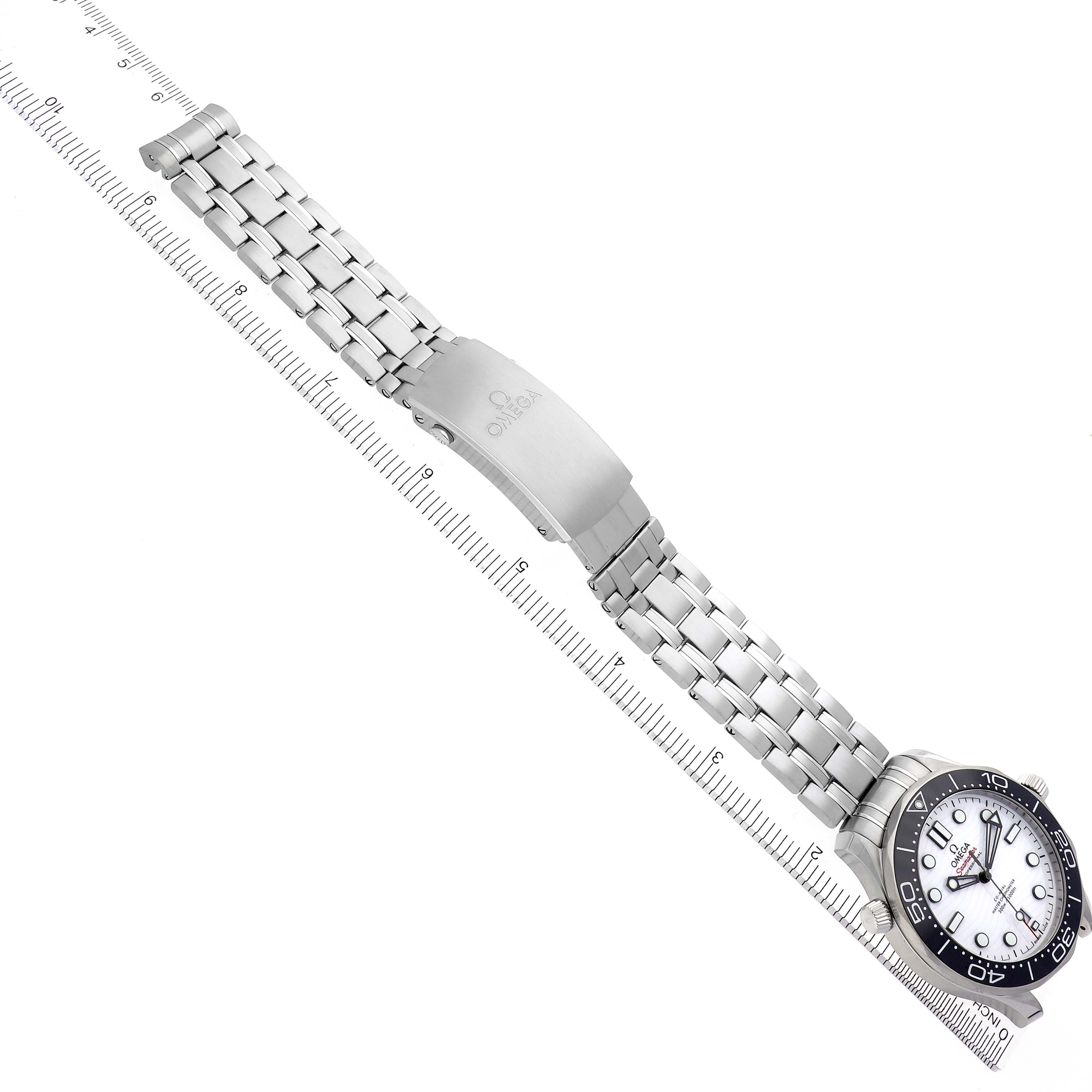The Omega Seamaster 210.30.42.20.04.001 Men
s Stainless Steel White Dial 210.30.42.20.04.001 Men
s Stainless Steel White Dial watch is shown at an angle highlighting the face, bezel, and full metal bracelet, laid diagonally on a ruler.