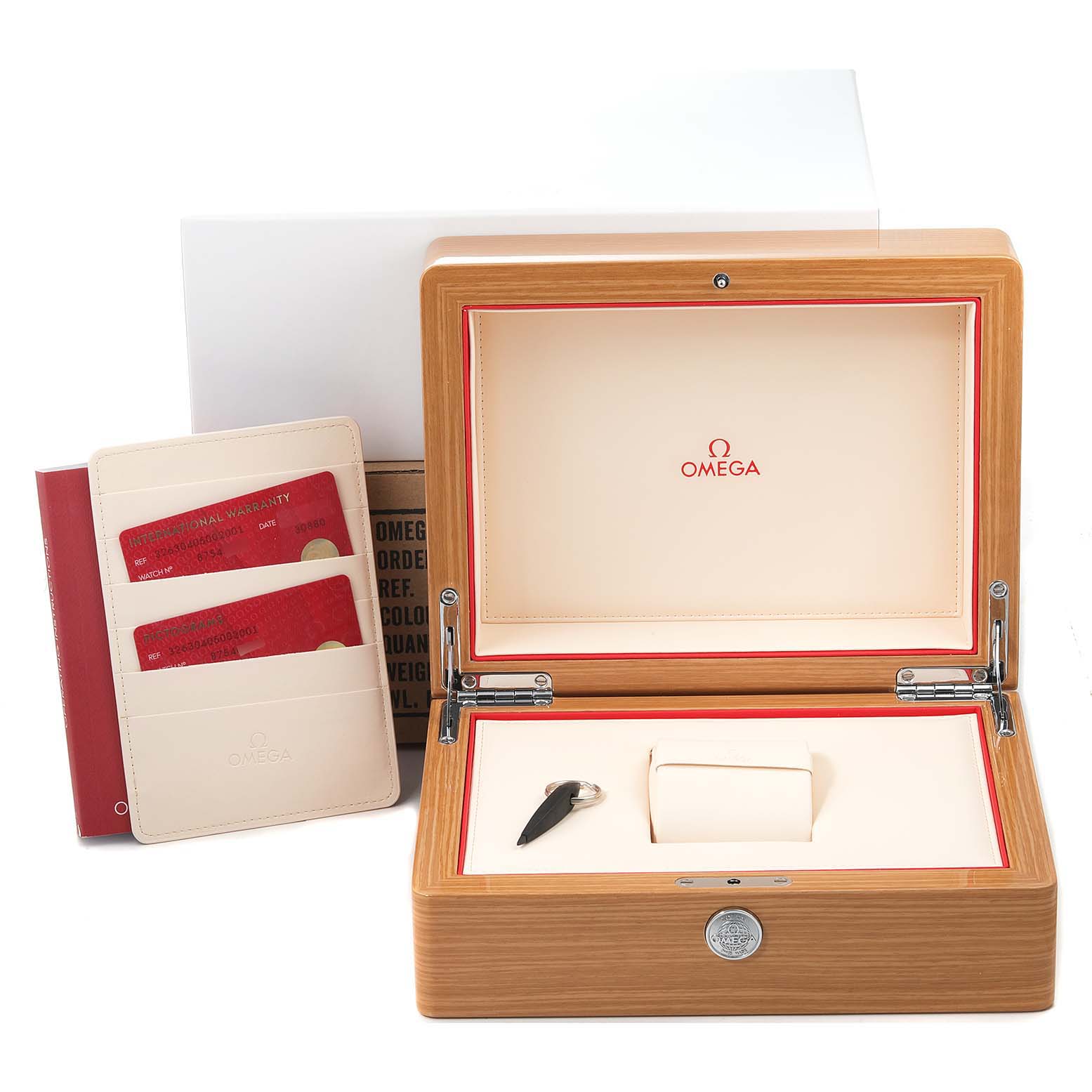 The image shows an Omega Speedmaster 326.30.40.50.02.001 Men's Stainless Steel Silver Dial 326.30.40.50.02.001 Men's Stainless Steel Silver Dial watch box, key, pillow cushion, and warranty cards at an angled view.