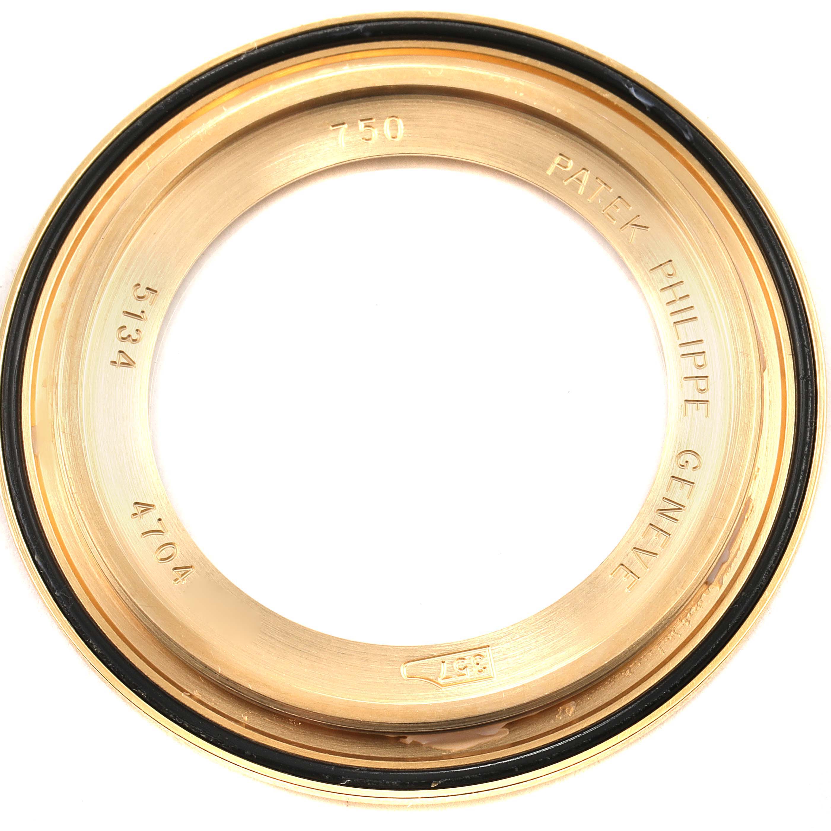 The image shows a close-up of the gold case back bezel for a Patek Philippe Calatrava 5134J Men's Yellow Gold White Dial 5134J Men's Yellow Gold White Dial watch.