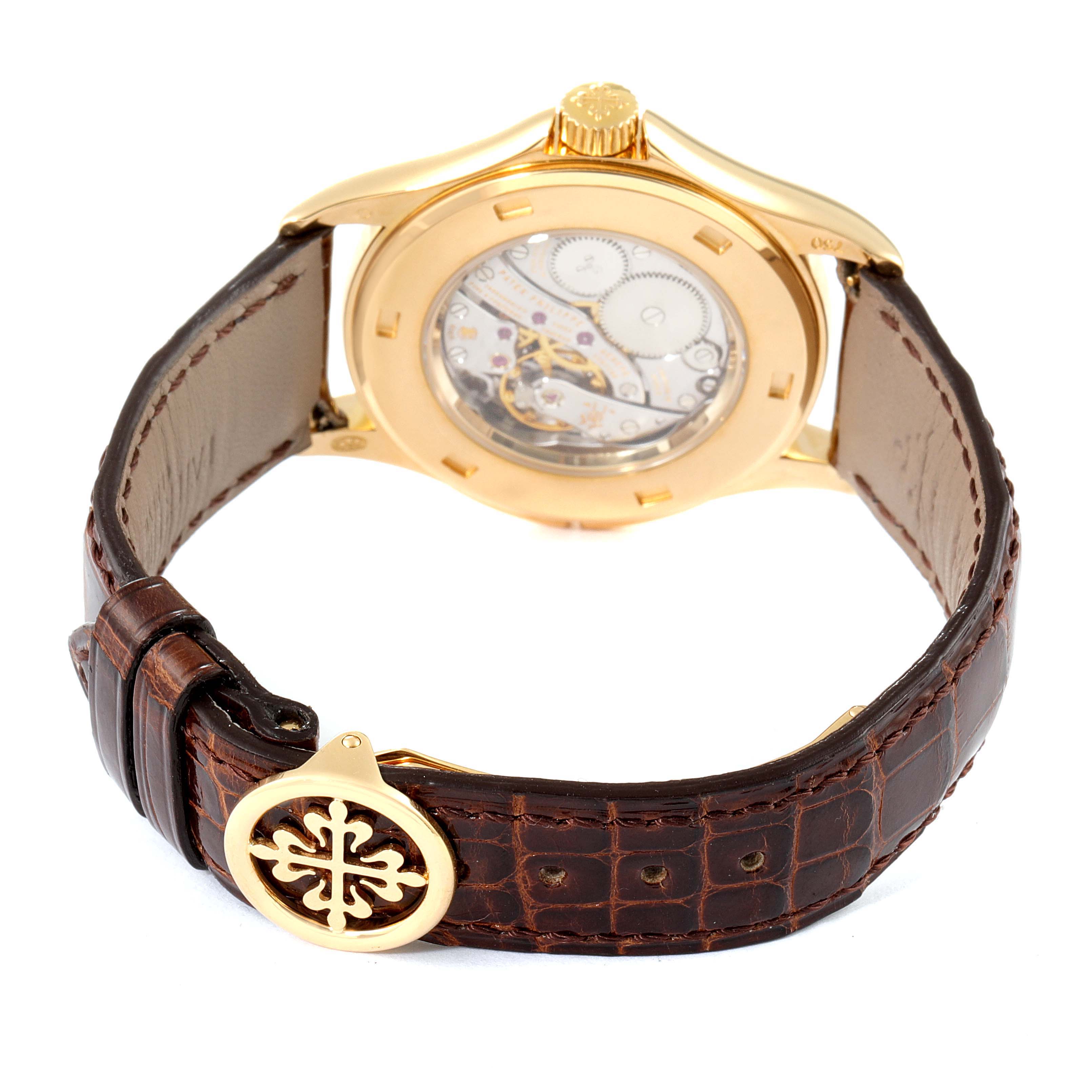 This image shows the back view of a Patek Philippe Calatrava 5134J Men's Yellow Gold White Dial 5134J Men's Yellow Gold White Dial watch, highlighting its movement and brown leather strap.
