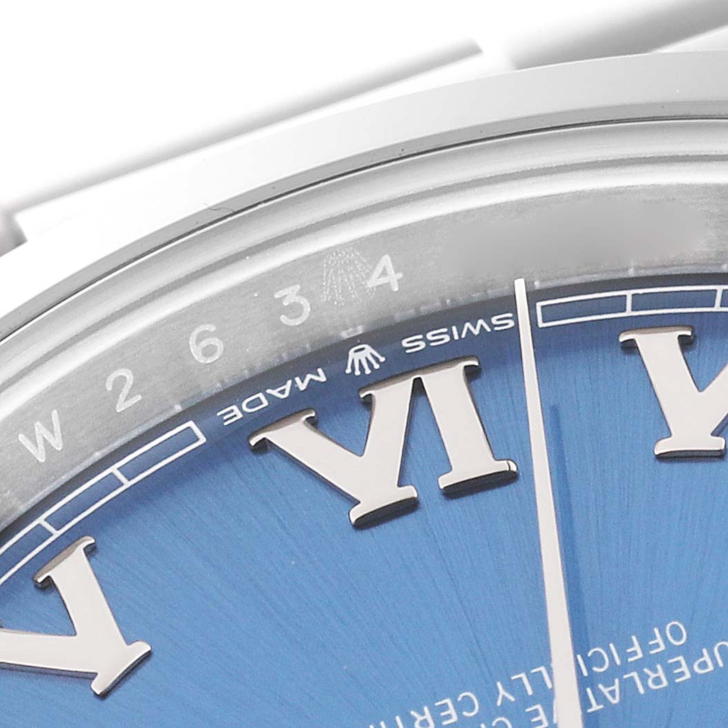 This close-up image shows the upper part of the Rolex Datejust 41 126300 Men
s Stainless Steel Blue Dial 126300 Men
s Stainless Steel Blue Dial watch
s dial and bezel, highlighting the Roman numeral hour markers and some text details.