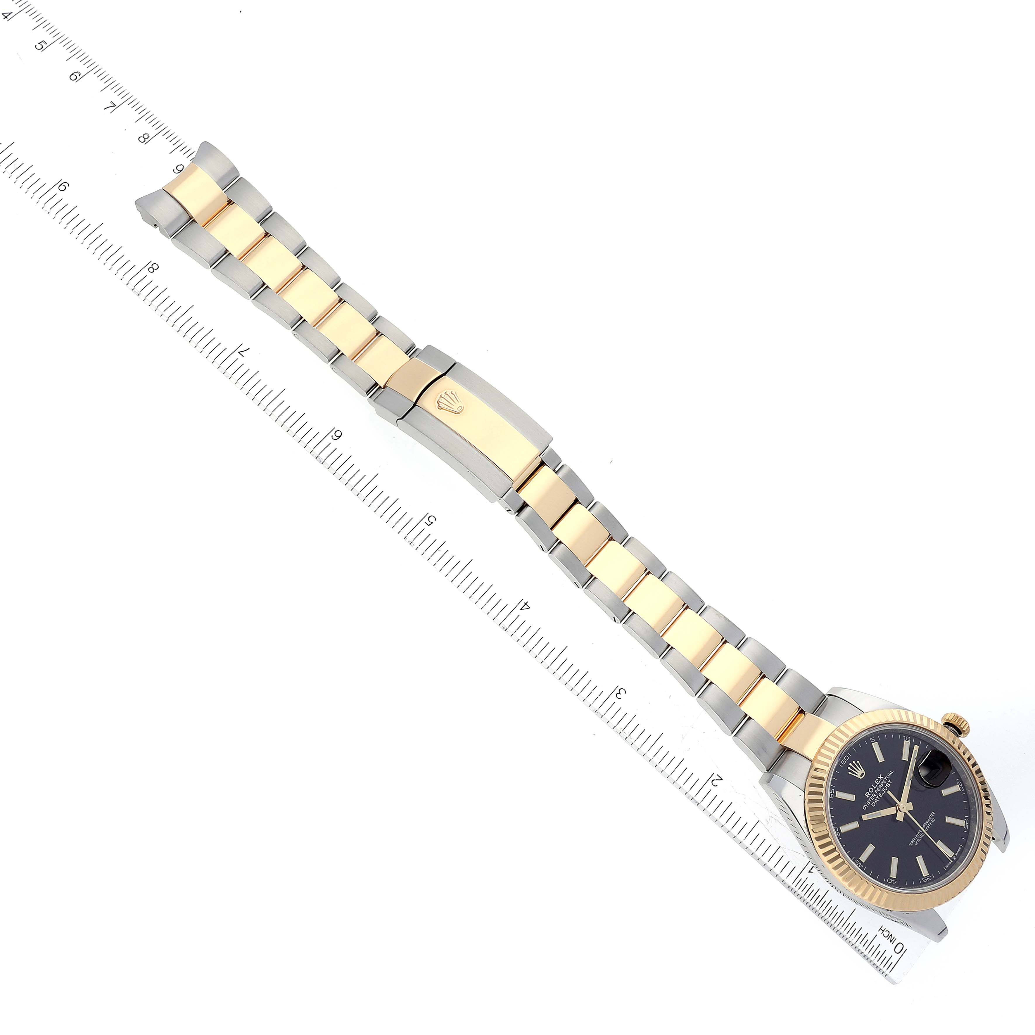 This image shows a top-down view of a Rolex Datejust 41 126333 Men's Steel and Gold (two tone) Black Dial 126333 Men's Steel and Gold (two tone) Black Dial watch, displaying the dial, bracelet, and clasp next to a measuring scale.