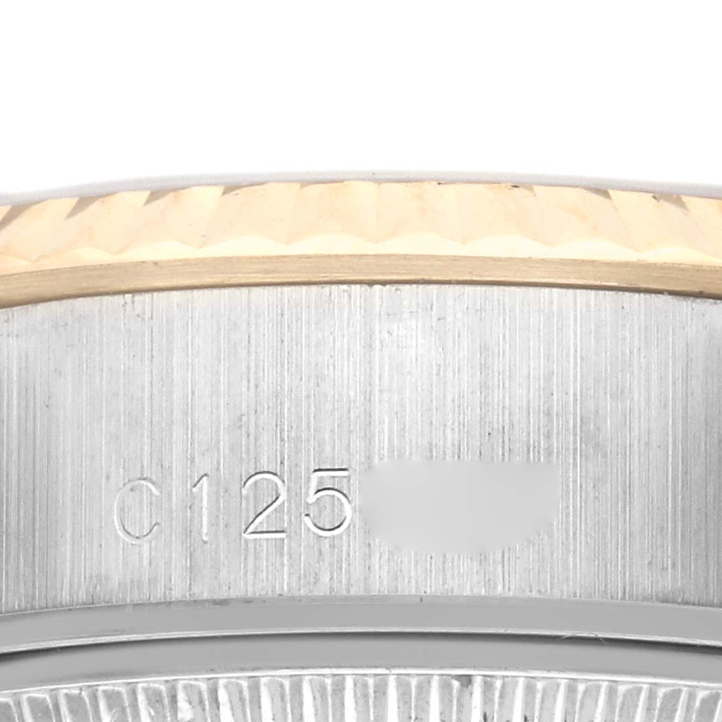 This image shows a close-up of the Rolex Datejust 69173 Women's Steel and Gold (two tone) Black Dial 69173 Women's Steel and Gold (two tone) Black Dial case edge with engraved serial numbers.