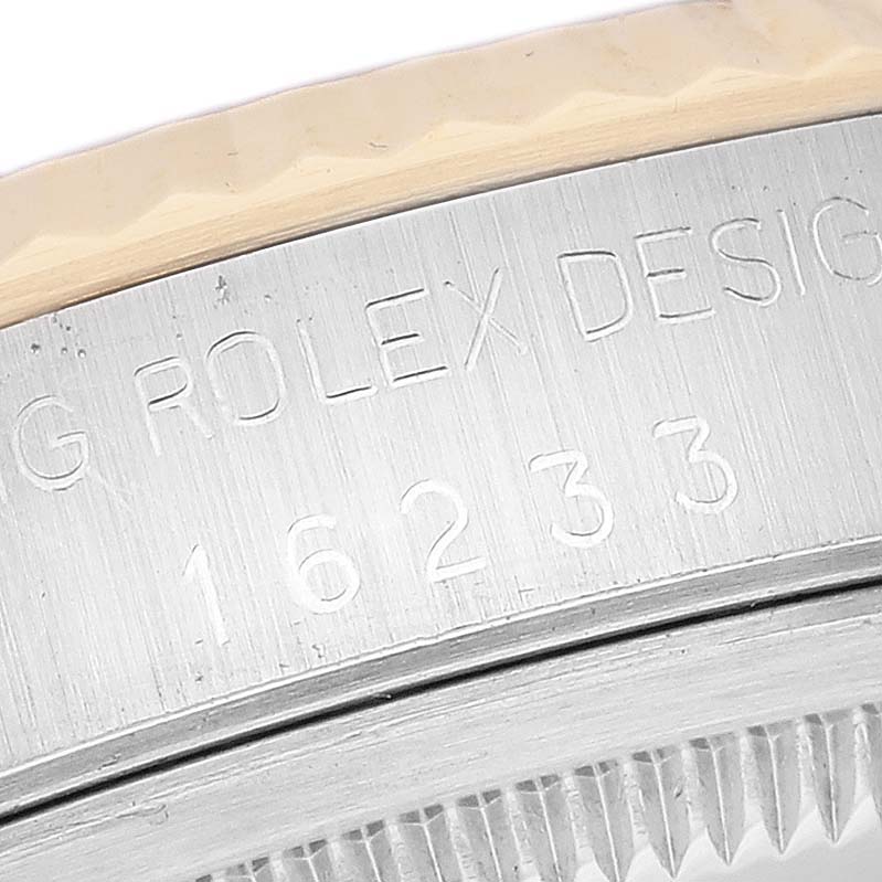 The image shows a close-up of the engraved case details of a Rolex Datejust 16233G Men's Steel and Gold (two tone) Blue Dial 16233G Men's Steel and Gold (two tone) Blue Dial model, including the reference number 16233.