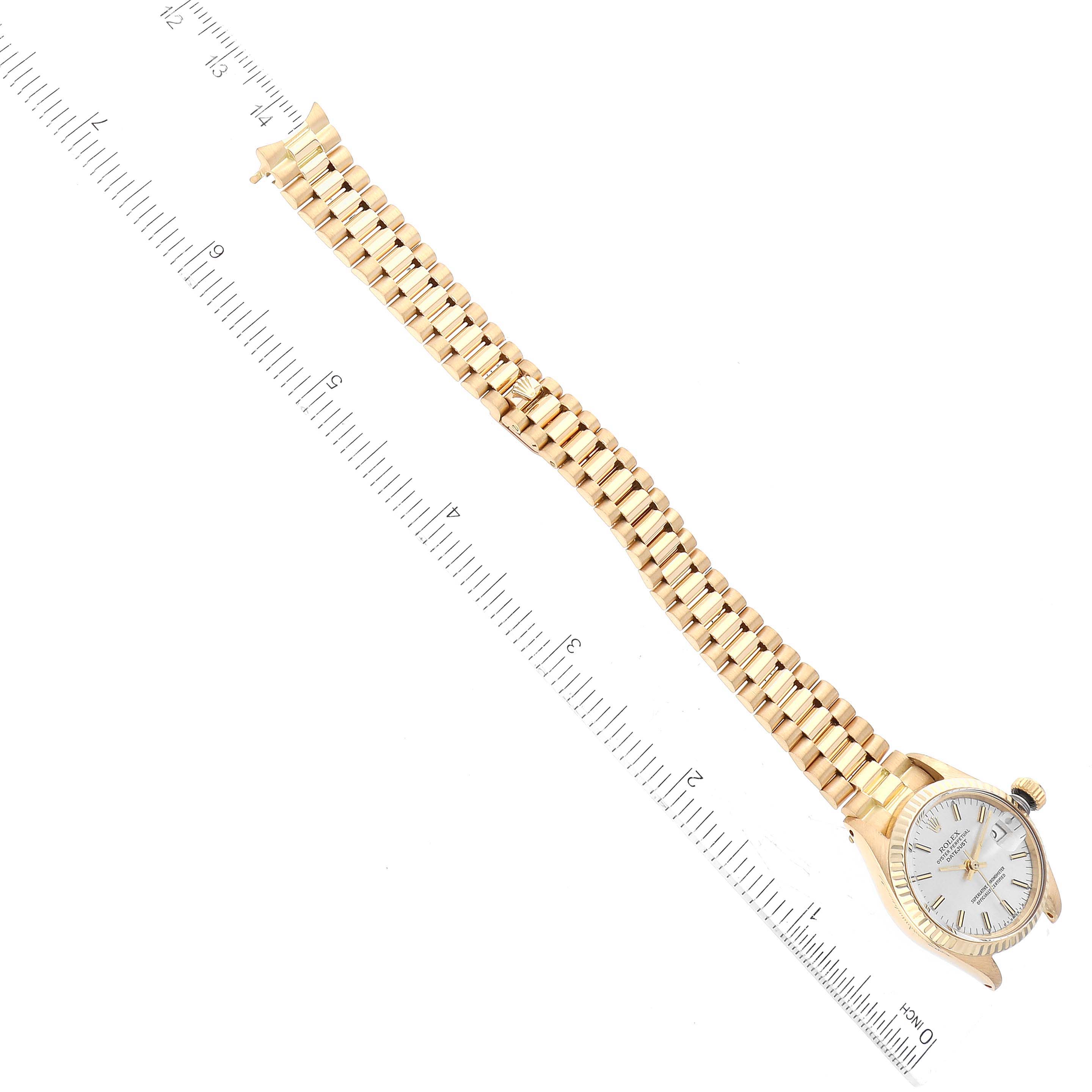 The image shows a Rolex President 6917 Women's Yellow Gold Silver Dial 6917 Women's Yellow Gold Silver Dial model watch, viewed from above, with a close-up of its bracelet and dial alongside a measuring ruler.