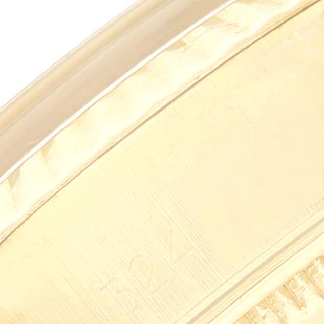 This close-up image of the Rolex President 6917 Women's Yellow Gold Silver Dial 6917 Women's Yellow Gold Silver Dial model showcases part of the bezel and case with a partial serial number.