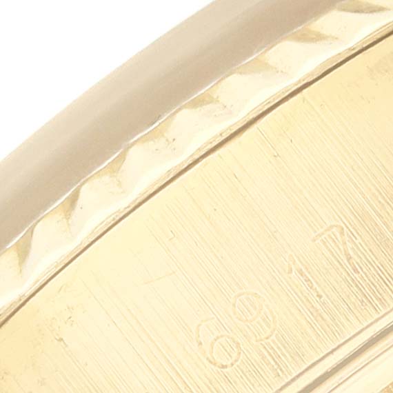 This close-up image shows a portion of the bezel and case of a Rolex President 6917 Women's Yellow Gold Silver Dial 6917 Women's Yellow Gold Silver Dial watch.