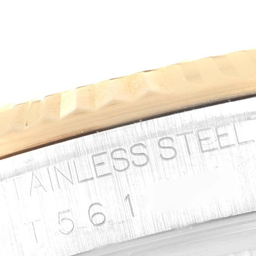 The image shows a close-up of the fluted bezel and part of the case with engraving on a Rolex Datejust 16233 Men's Steel and Gold (two tone) Blue Dial 16233 Men's Steel and Gold (two tone) Blue Dial watch.