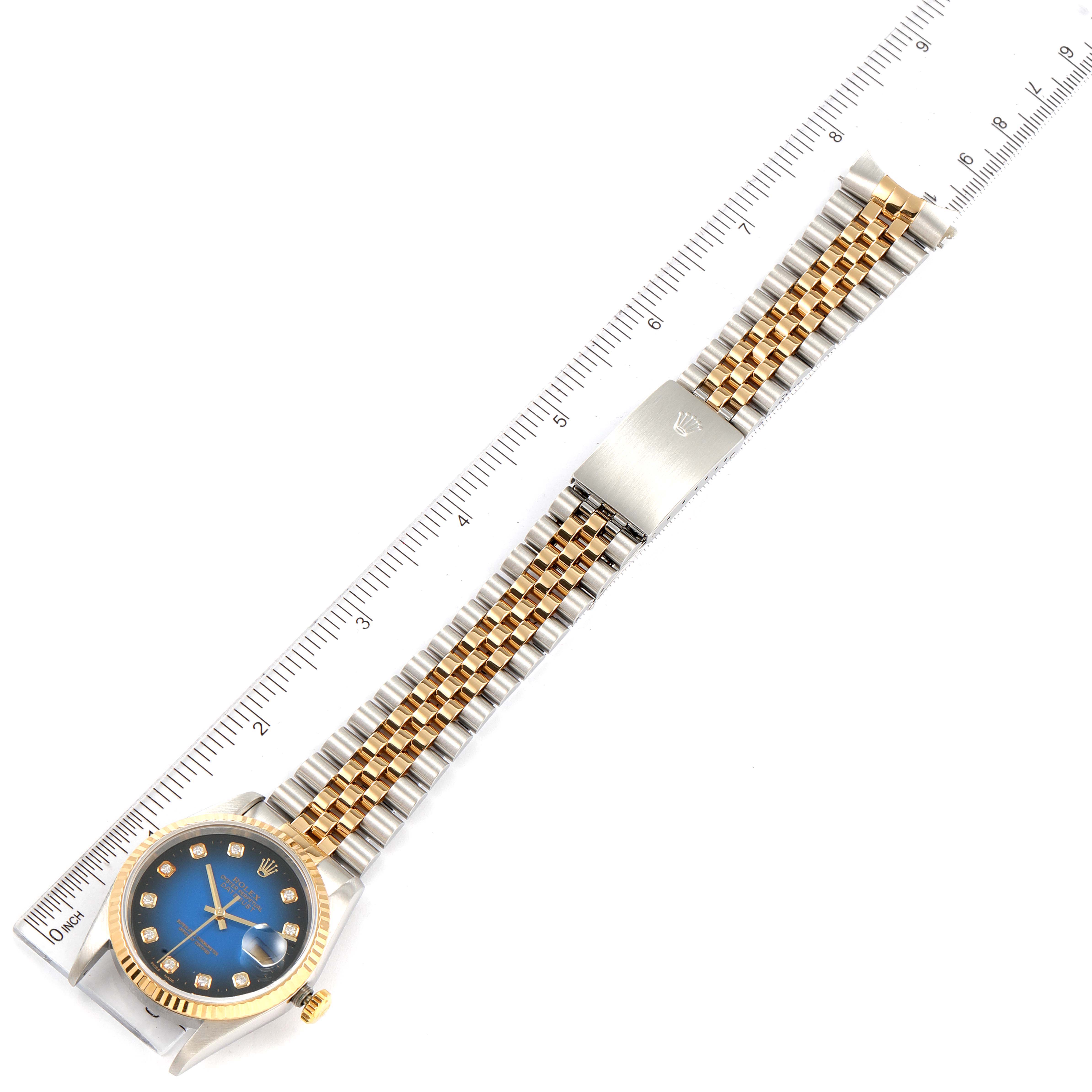 The image shows a top view of a Rolex Datejust 16233 Men's Steel and Gold (two tone) Blue Dial 16233 Men's Steel and Gold (two tone) Blue Dial watch with a ruler beside it, displaying the watch face and bracelet.