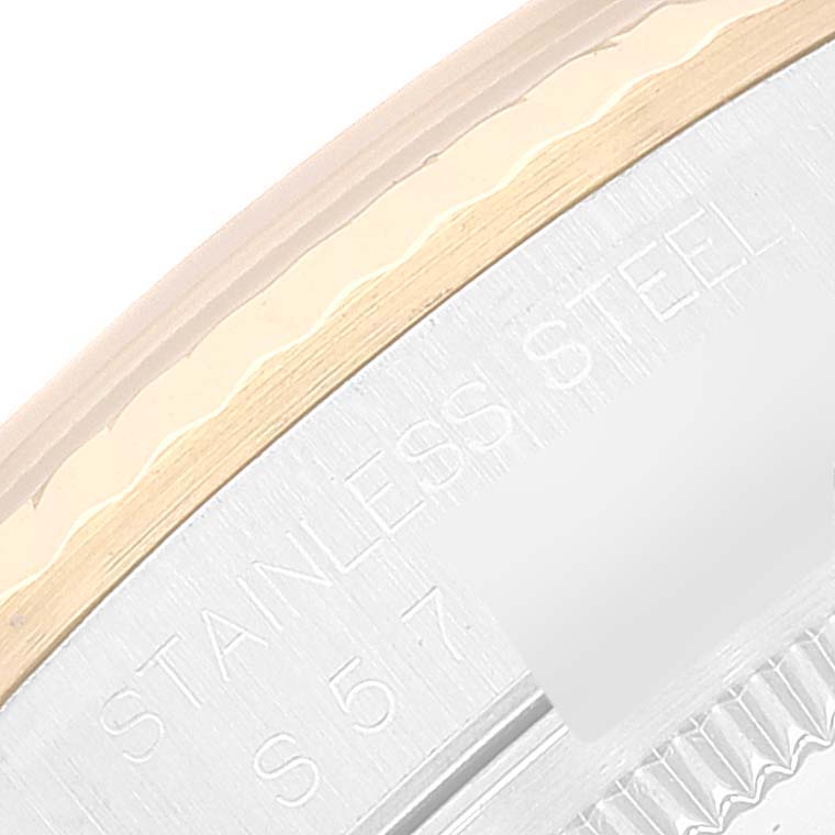 The image shows a close-up of the stainless steel and gold bezel engraving on a Datejust model by Rolex.