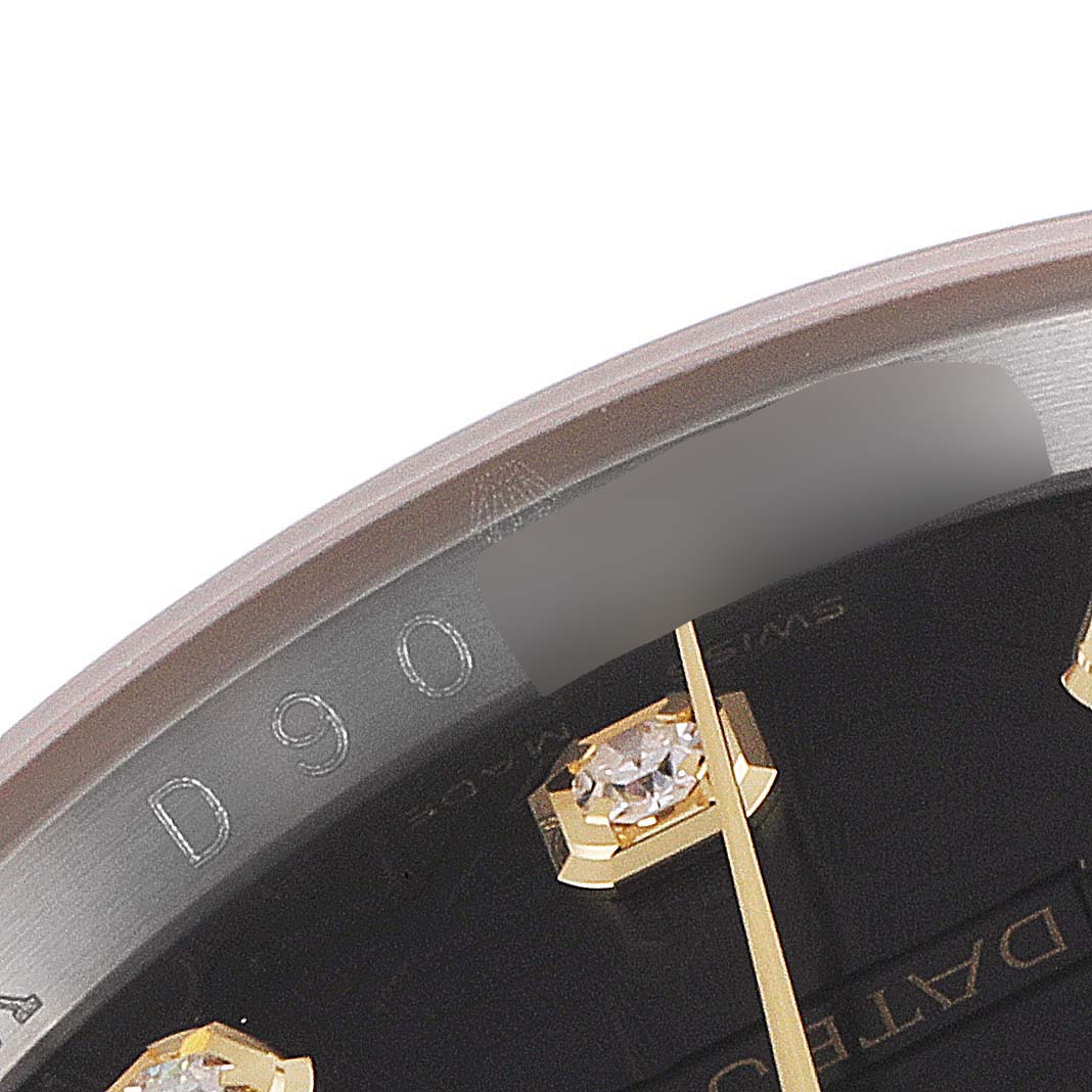 This close-up image of the Rolex Datejust 116233 Men's Steel and Gold (two tone) Black Dial 116233 Men's Steel and Gold (two tone) Black Dial watch shows part of the dial, including diamond hour markers and engravings on the inner bezel.