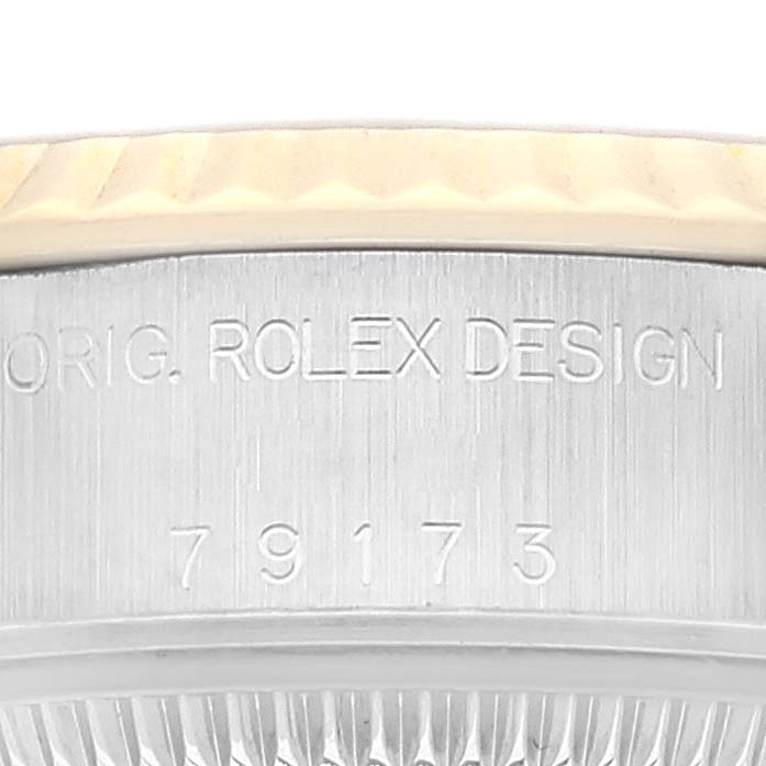 The image shows a close-up of the case side of a Rolex Datejust 79173 Women's Steel and Gold (two tone) Champagne Dial 79173 Women's Steel and Gold (two tone) Champagne Dial watch, highlighting the engraved "ORIG. ROLEX DESIGN" and serial number.