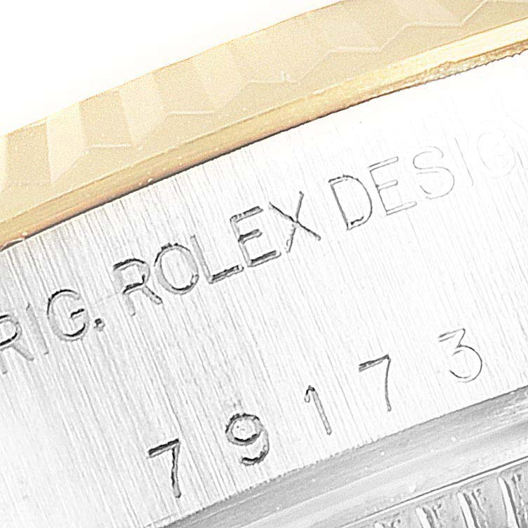 This image shows a close-up of the engraved text and serial number on the case of a Rolex Datejust 79173 Women's Steel and Gold (two tone) Champagne Dial 79173 Women's Steel and Gold (two tone) Champagne Dial watch.