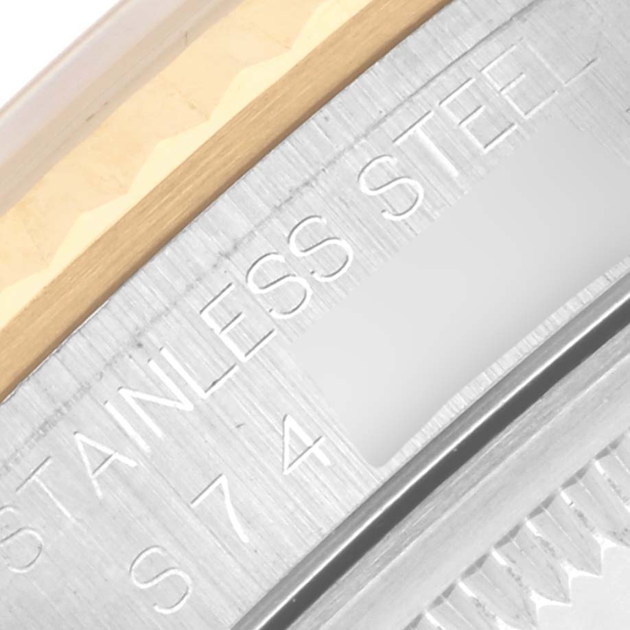 The image shows the edge of the bezel and the engraved side of a Rolex Datejust 16233 Men
s Steel and Gold (two tone) White Dial 16233 Men
s Steel and Gold (two tone) White Dial watch in stainless steel.