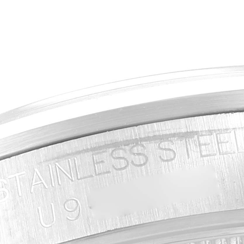 The image shows a close-up of the side profile and part of the bezel of a Mid-Size Rolex watch made of stainless steel.