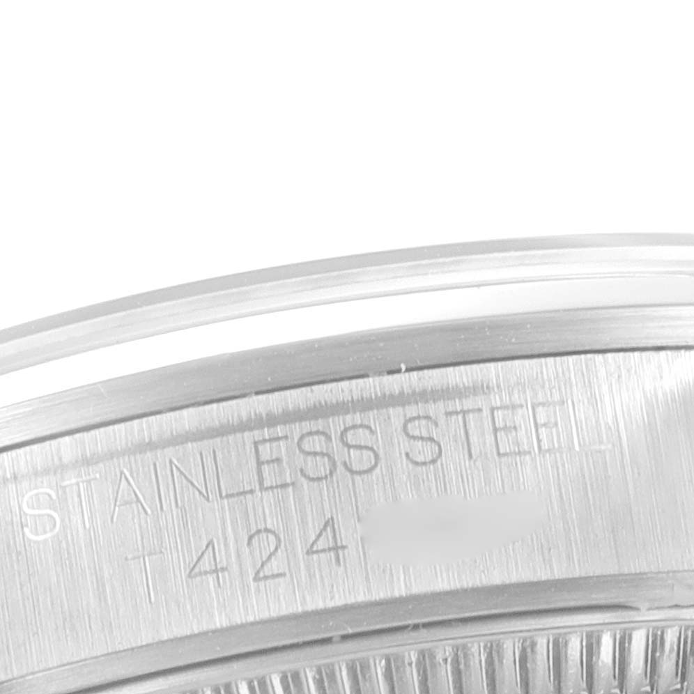 This is a close-up of the stainless steel back case of a mid-size Rolex watch.