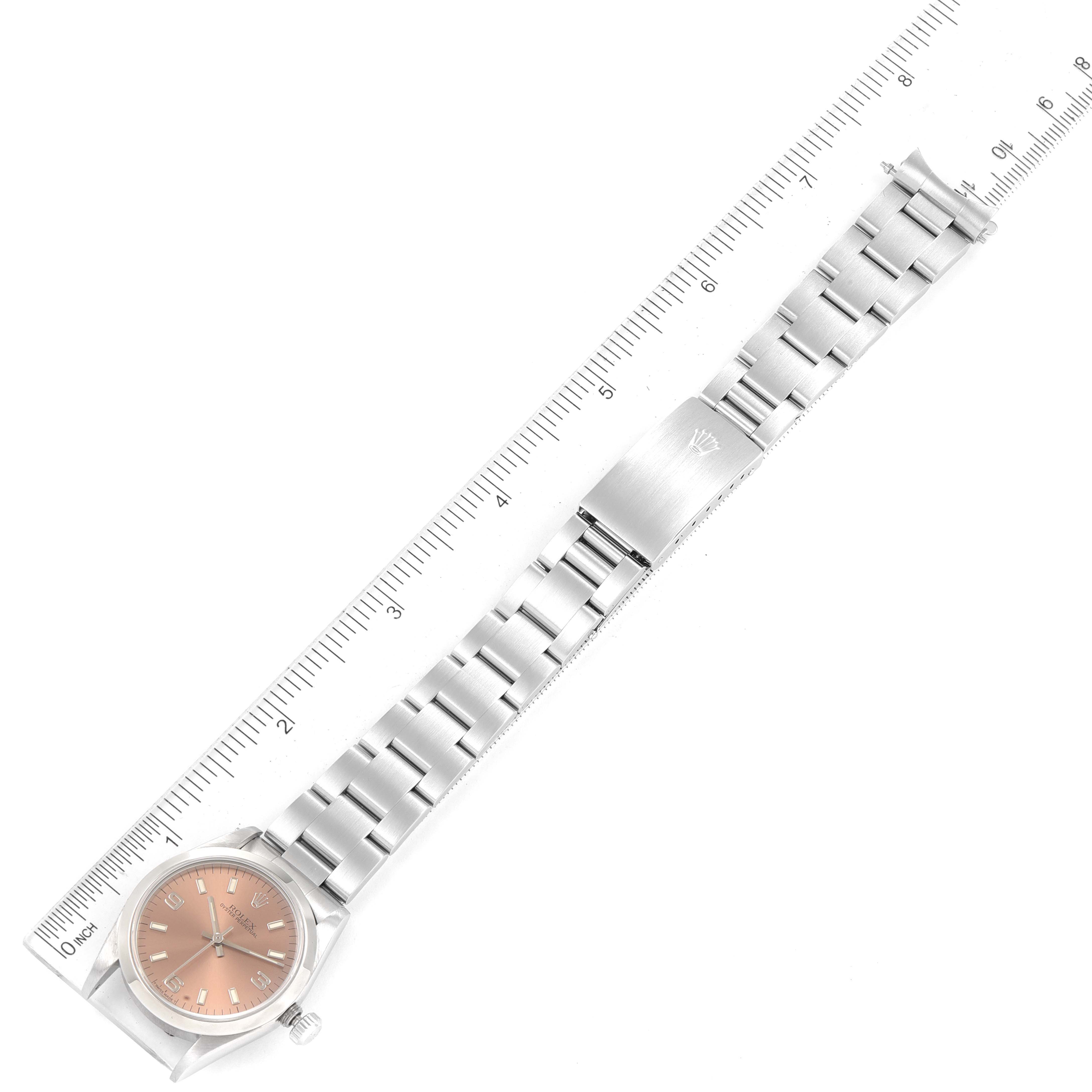 The image shows an overhead view of a Mid-Size Rolex watch, including the dial, bracelet, and clasp, measured against a ruler.