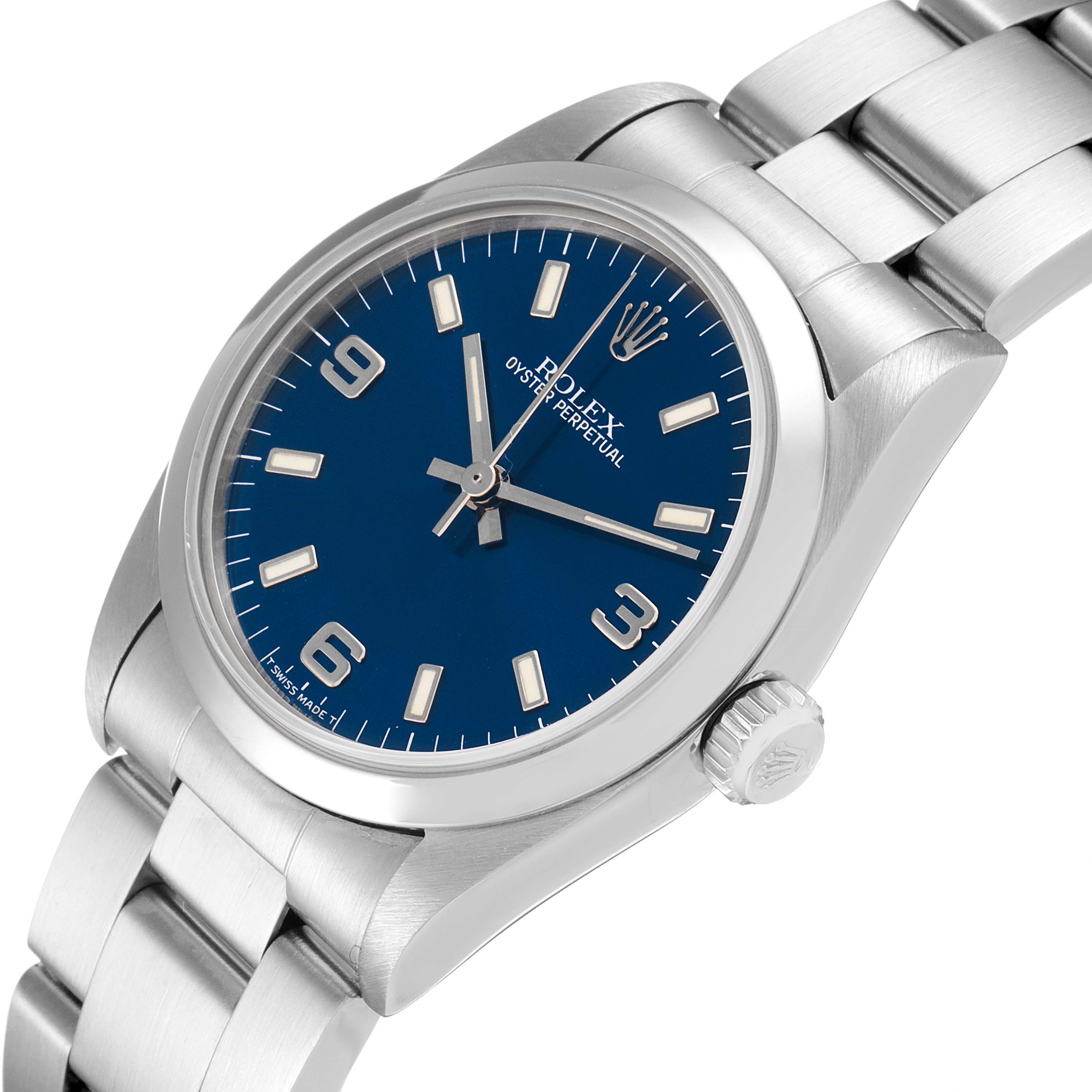 The image shows a Mid-Size Rolex Oyster Perpetual watch from an angled frontal view, displaying its blue dial, bezel, crown, and bracelet.