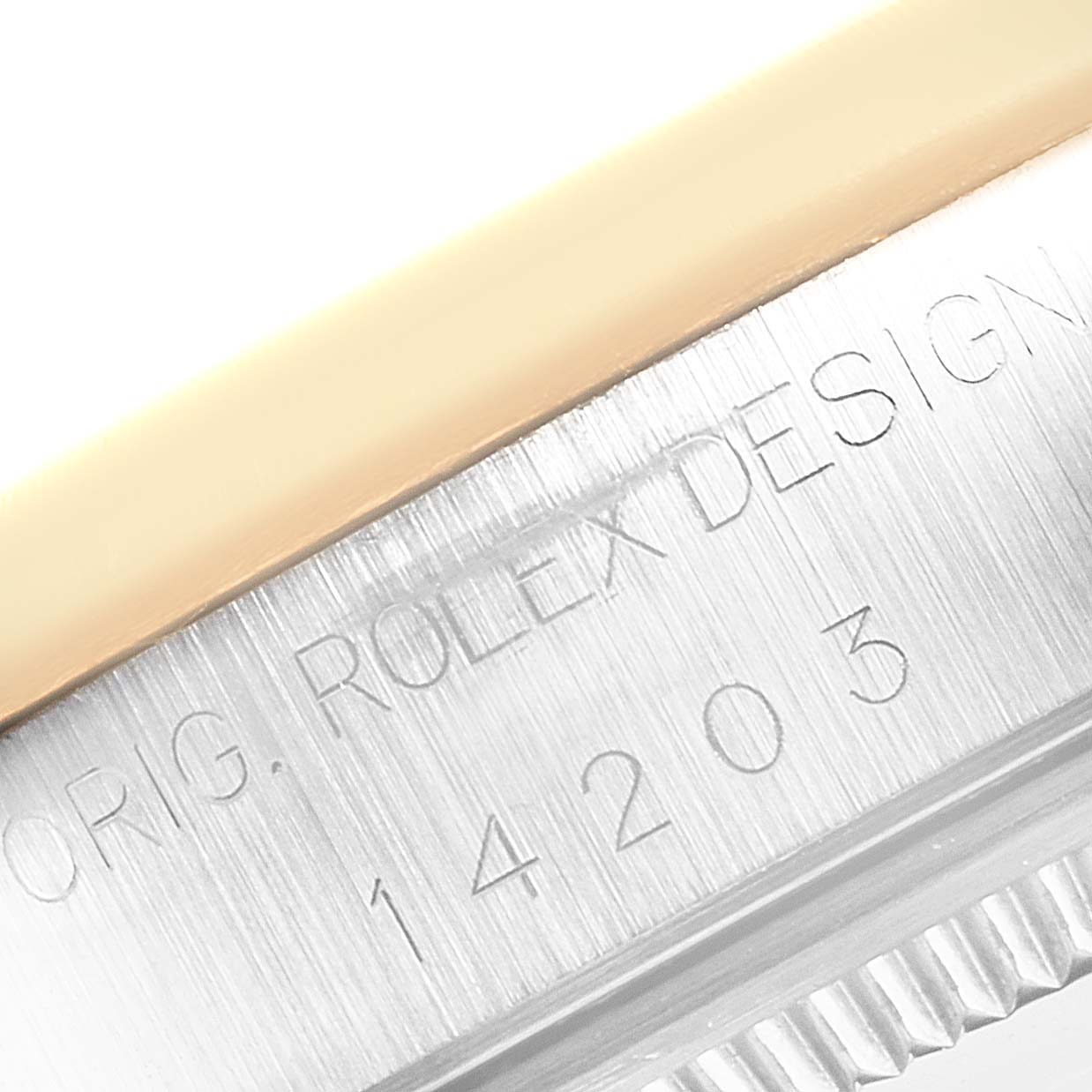 The image shows a close-up of the edge of the Rolex Oyster Perpetual 14203 Men
s Steel and Gold (two tone) Grey Dial 14203 Men
s Steel and Gold (two tone) Grey Dial watch case, displaying model engravings.