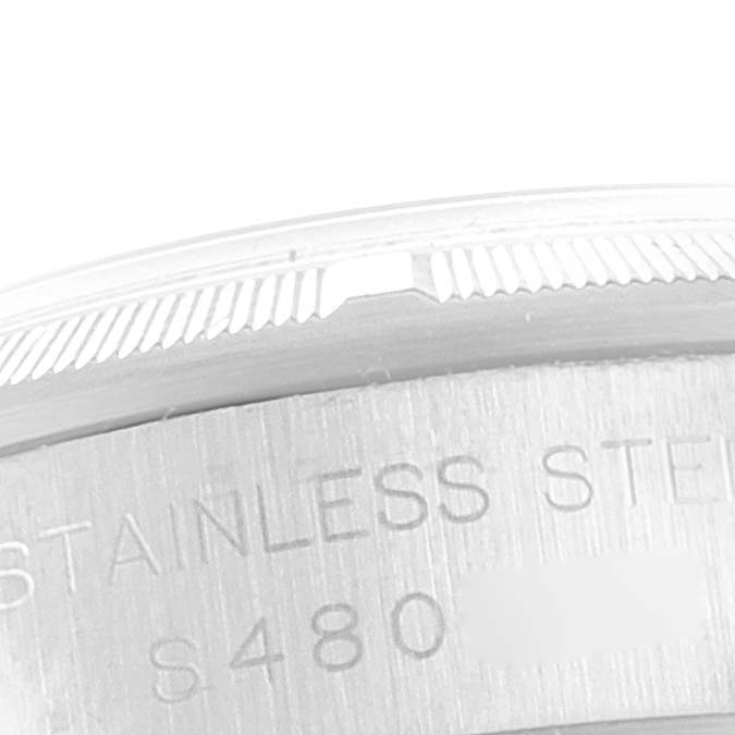 This image shows a close-up of the case back and part of the bezel with engraving of the Rolex Oyster Perpetual 67230 Women's Stainless Steel Grey Dial 67230 Women's Stainless Steel Grey Dial watch.