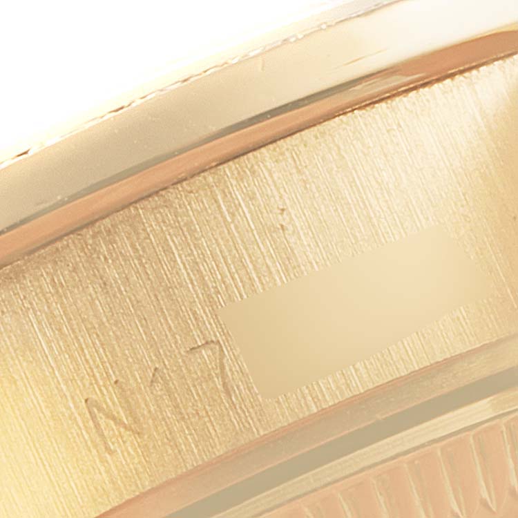 The image shows a close-up of a portion of the case back and the edge of the bezel of a Rolex President 69138 Women's Yellow Gold Champagne Dial 69138 Women's Yellow Gold Champagne Dial model watch.