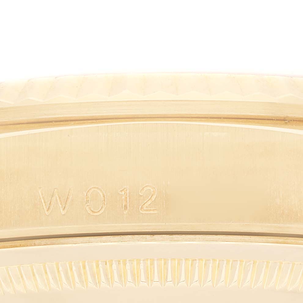This image shows a close-up of the side of a Rolex President 18338 Men's Yellow Gold Champagne Dial 18338 Men's Yellow Gold Champagne Dial model watch, focusing on its serial number and part of the bezel.