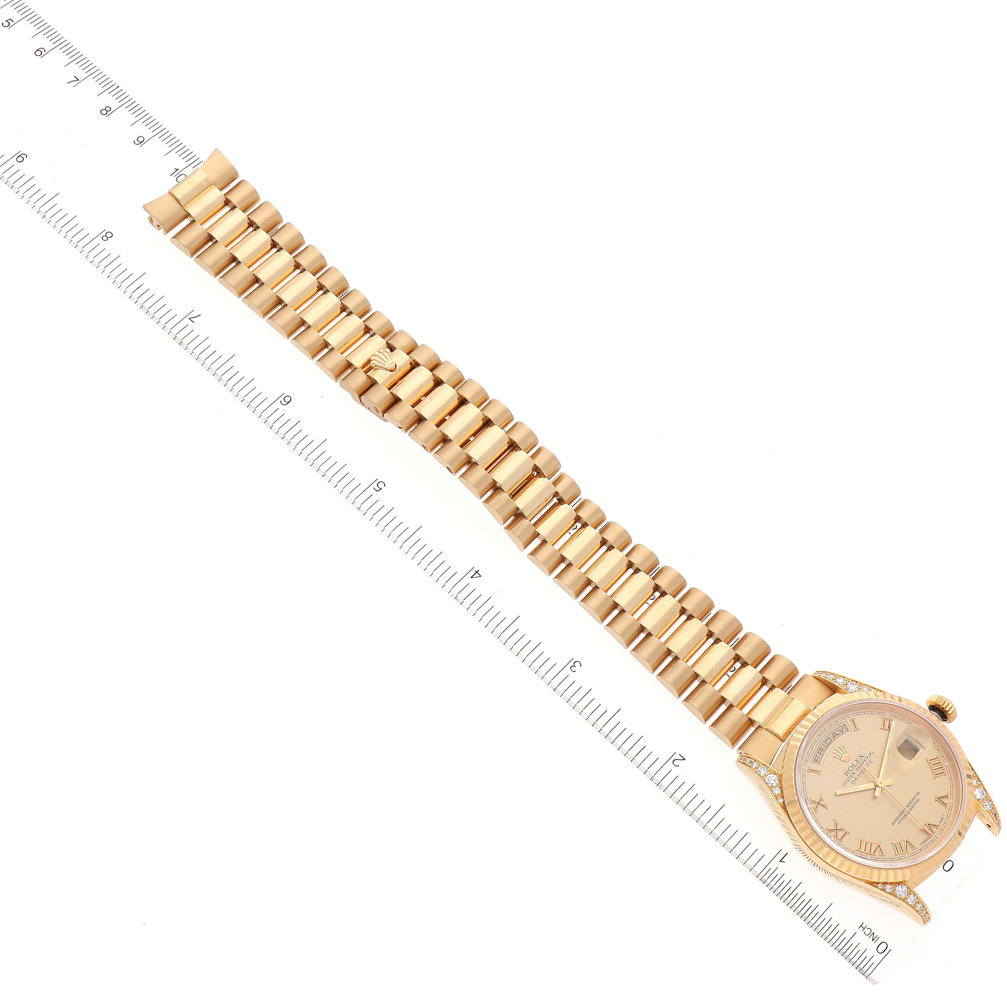 This image shows a Rolex President 18338 Men's Yellow Gold Champagne Dial 18338 Men's Yellow Gold Champagne Dial watch from a top-down angle, with a focus on its gold bracelet and diamond-set case.