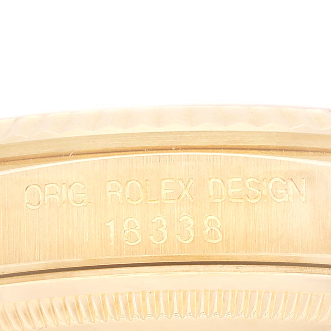 This image shows a close-up of the edge of the Rolex President 18338 Men's Yellow Gold Champagne Dial 18338 Men's Yellow Gold Champagne Dial watch case, featuring the engraved model number 18338 and "ORIG ROLEX DESIGN."