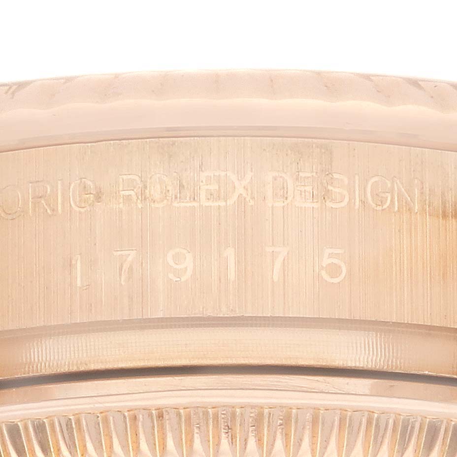 The image shows a close-up of the side engraving on a Rolex President 179175 Women's Rose Gold Silver Dial 179175 Women's Rose Gold Silver Dial model, focusing on the serial number and fluted bezel.