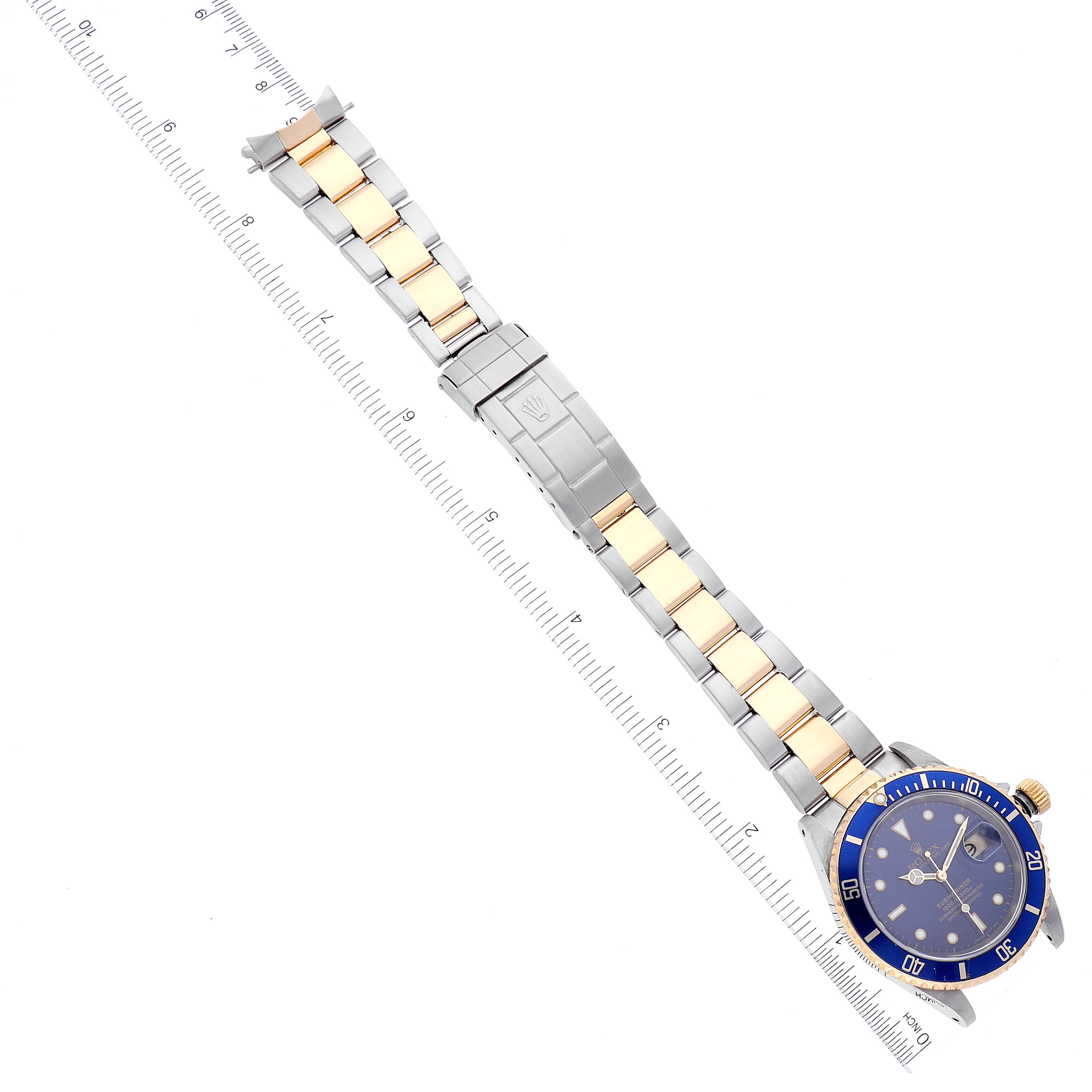 The image shows a top view of a Rolex Submariner 16613 Men's Steel and Gold (two tone) Blue Dial 16613 Men's Steel and Gold (two tone) Blue Dial watch, highlighting the full length of its band and bezel.