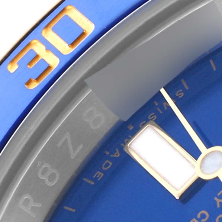 The image shows a close-up of a Rolex Submariner 116613 Men's Steel and Gold (two tone) Blue Dial 116613 Men's Steel and Gold (two tone) Blue Dial's blue dial, bezel, and part of the gold indices.