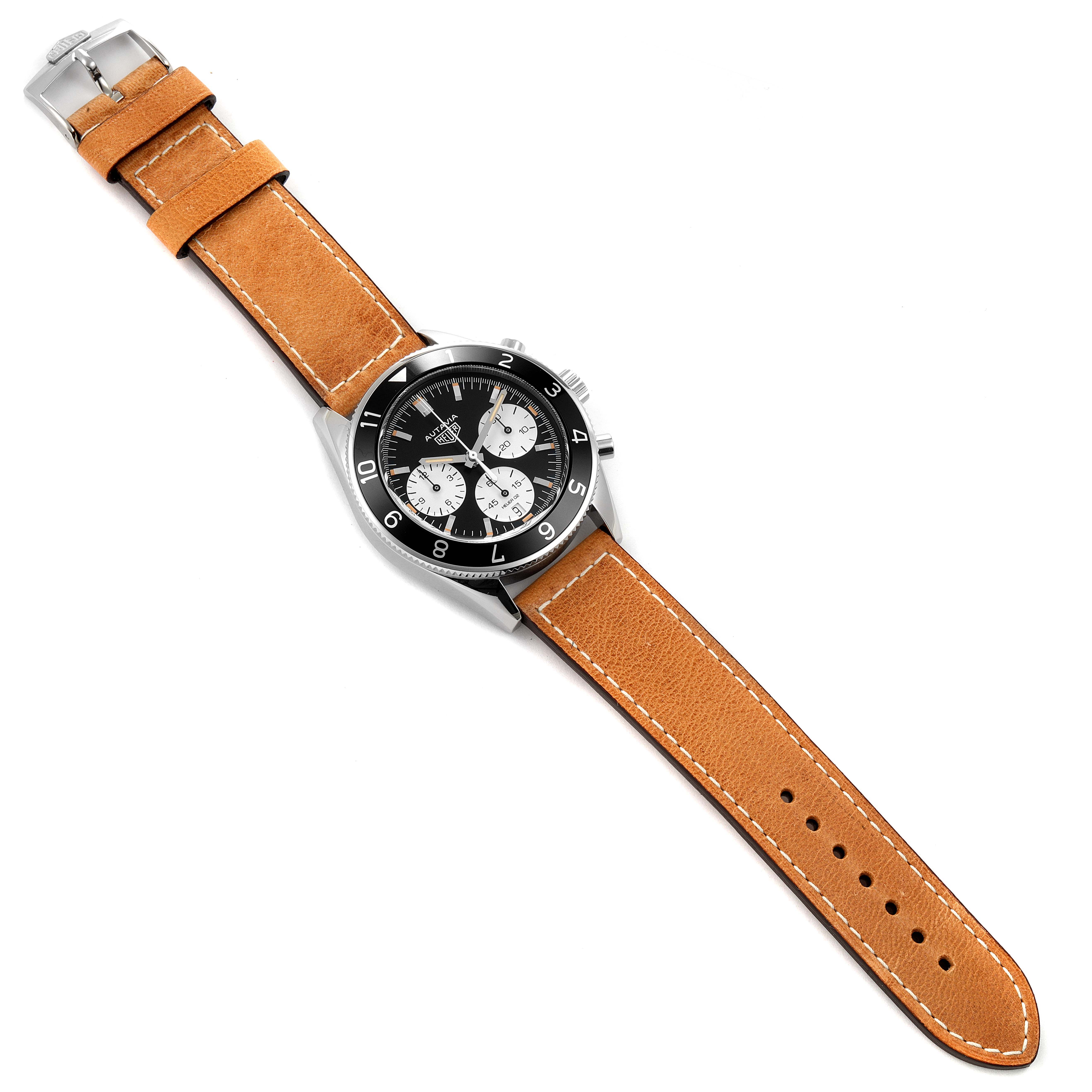 The Autavia model by Tag Heuer is shown from an overhead angle, displaying the watch face, leather strap, and buckle.