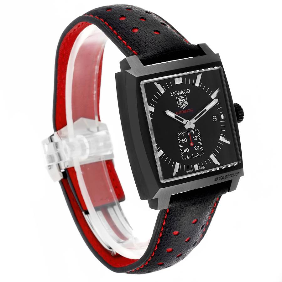 The Tag Heuer Monaco watch is shown at an angle highlighting the face, dial, and perforated black and red strap.