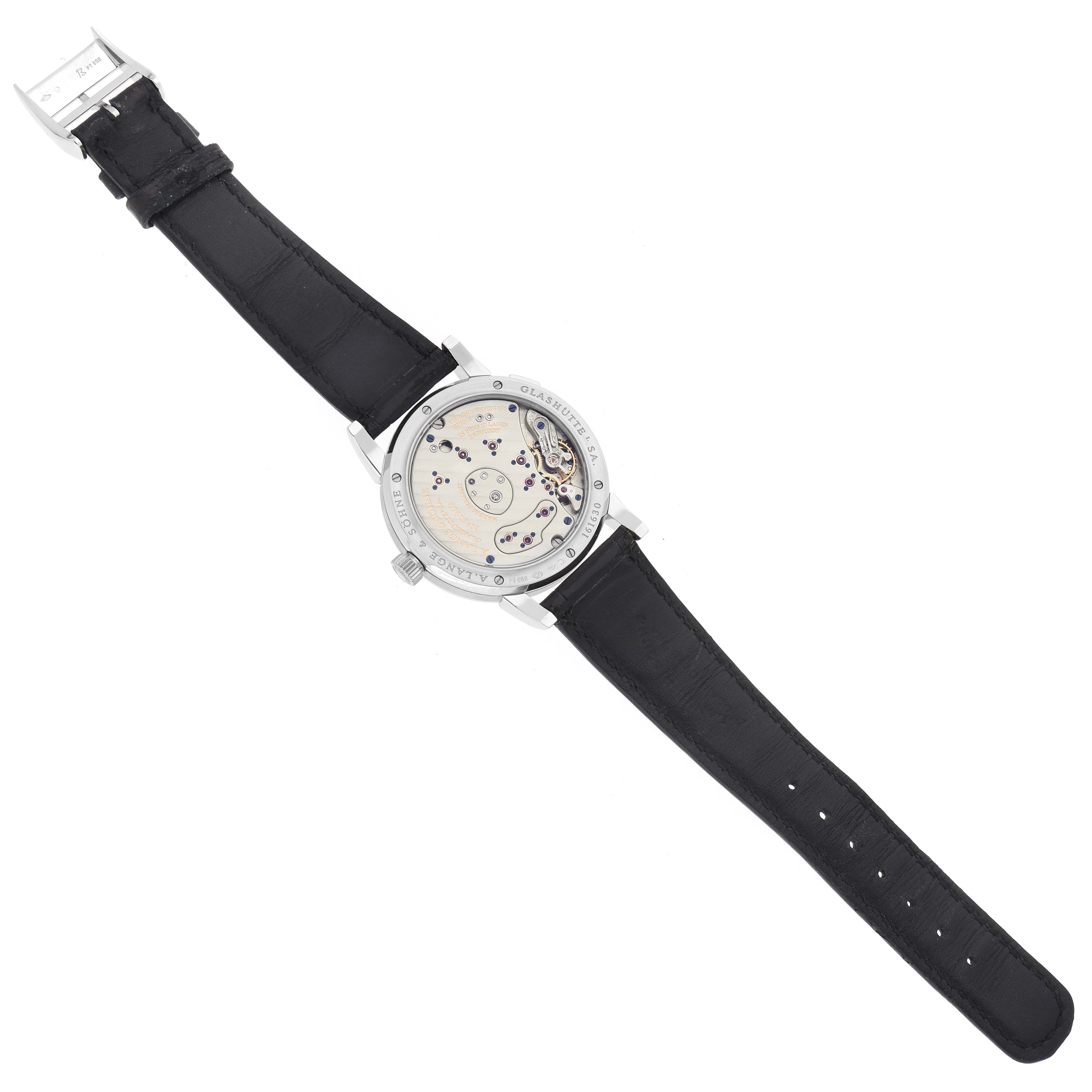 The image shows the back view of the A. Lange & Sohne Lange 1 109.025 Men's Platinum Silver Dial, revealing its intricate movement and black leather strap.