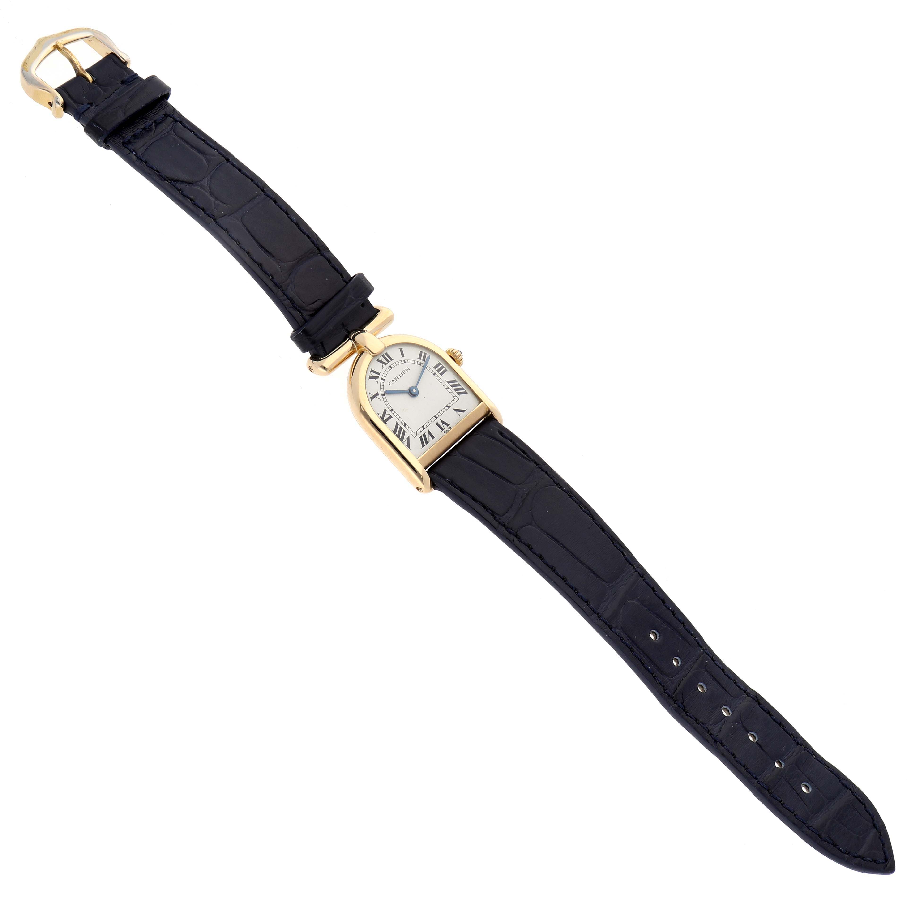 The Cartier Cloche Calandre 81082 Women
s Yellow Gold Silver Dial 81082 Women
s Yellow Gold Silver Dial watch is shown from a top-down angle, highlighting its strap, buckle, and unique case shape.