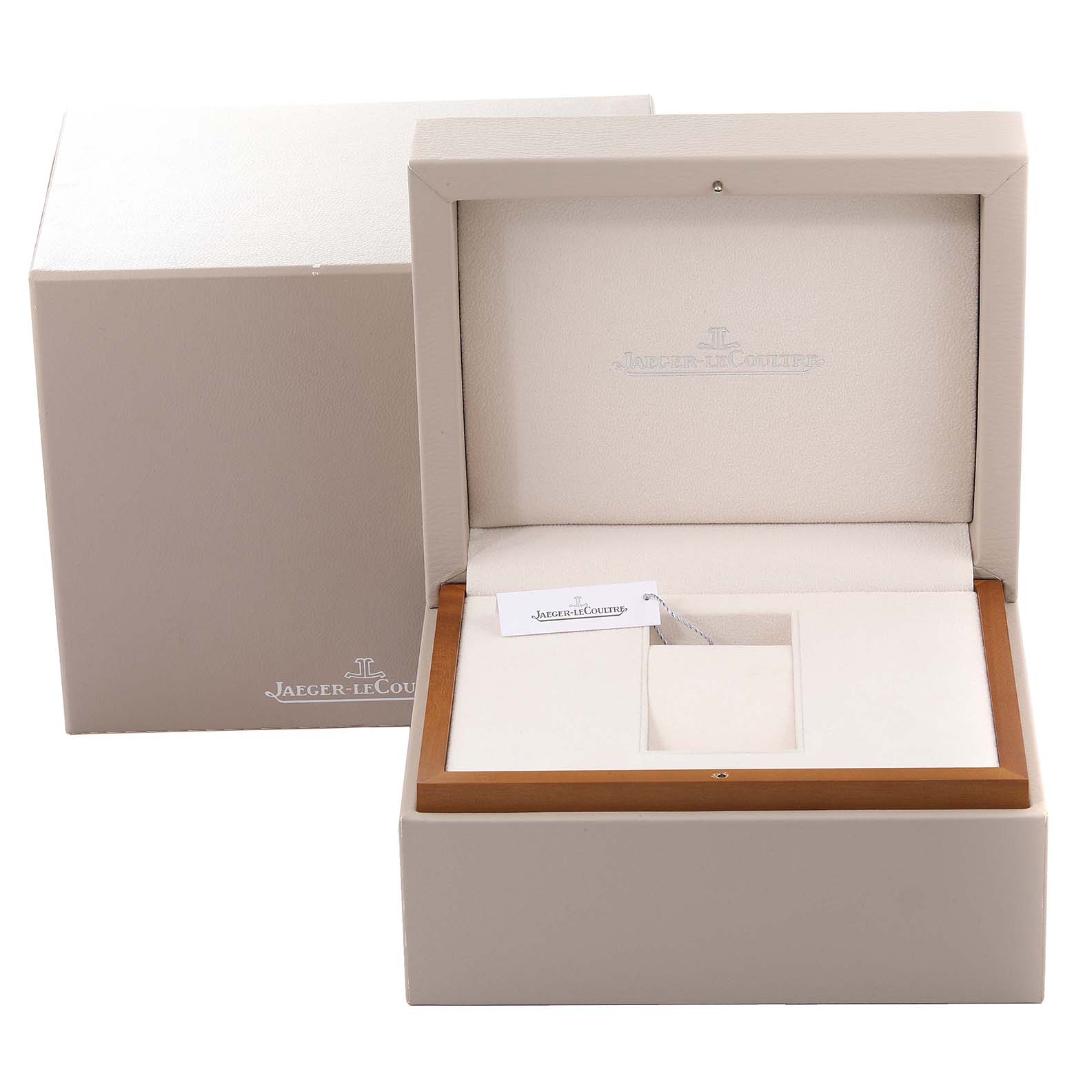 The image shows an open watch box for a Jaeger-LeCoultre Reverso watch, displaying internal compartments and branded tags.