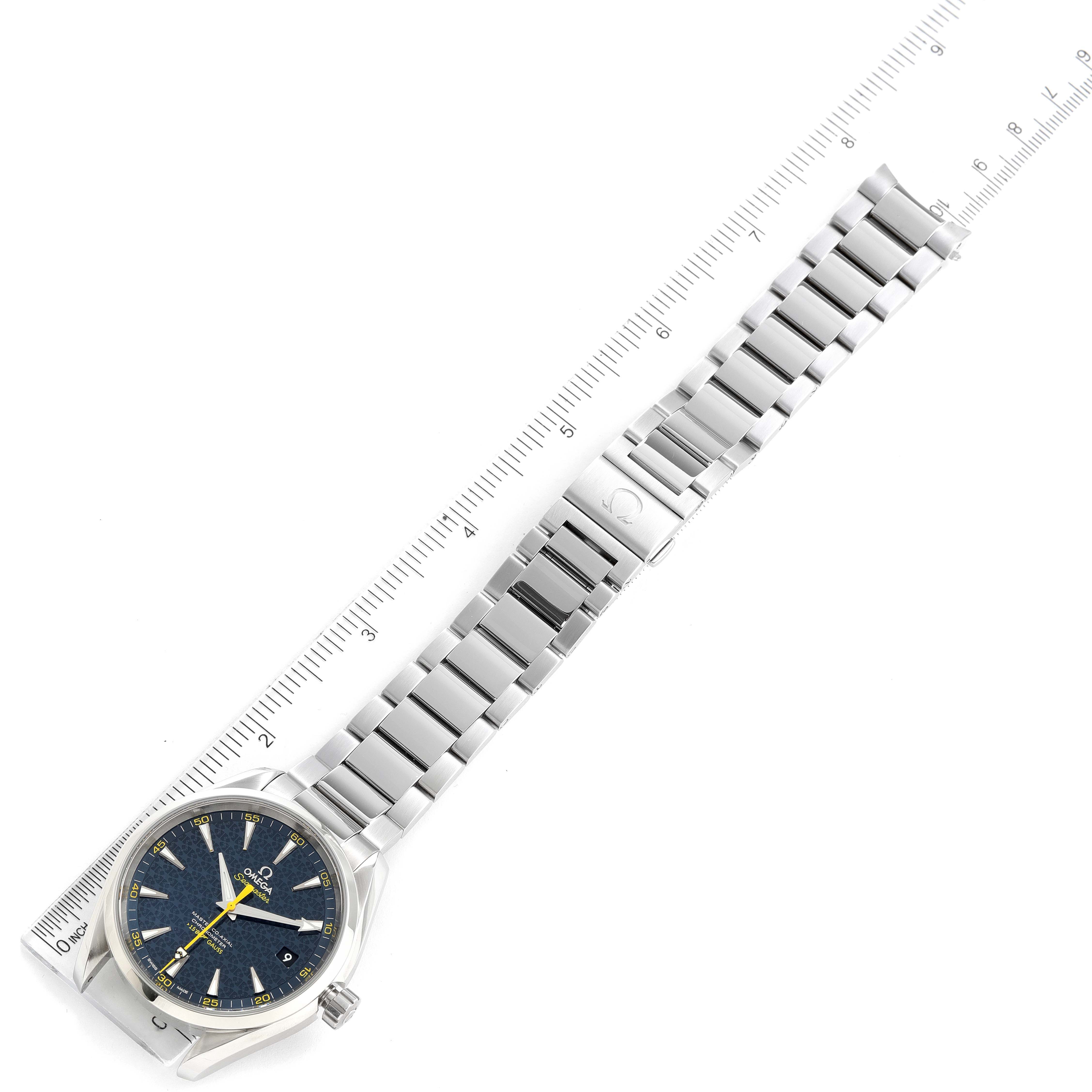 The image shows an Aqua Terra model by Omega, featuring the watch face and its silver metal bracelet, aligned with a ruler.