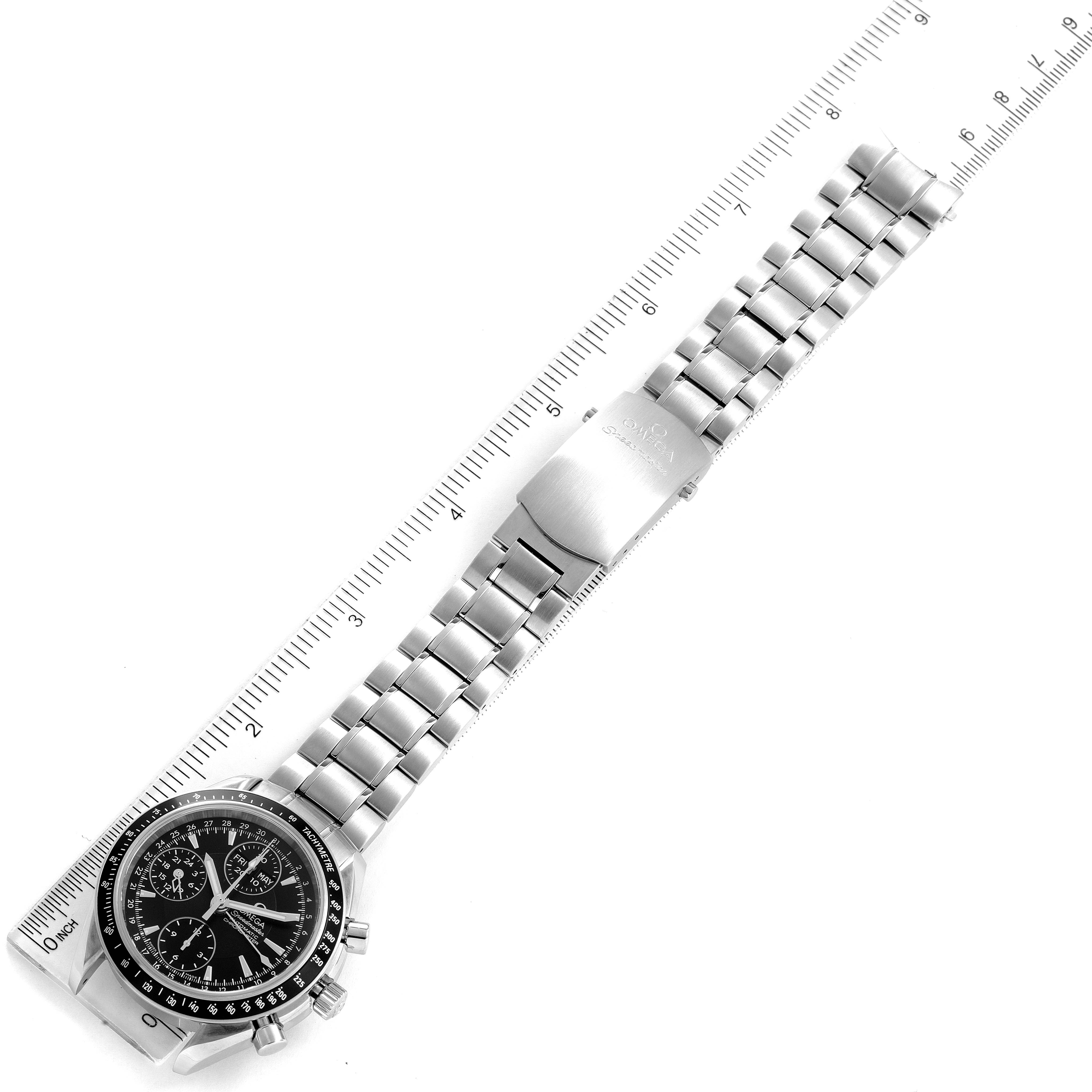 The Omega Speedmaster 3220.50.00 Men's Stainless Steel Black Dial 3220.50.00 Men's Stainless Steel Black Dial watch is shown from an aerial view, displaying its dial, bracelet, and clasp alongside a ruler for scale.