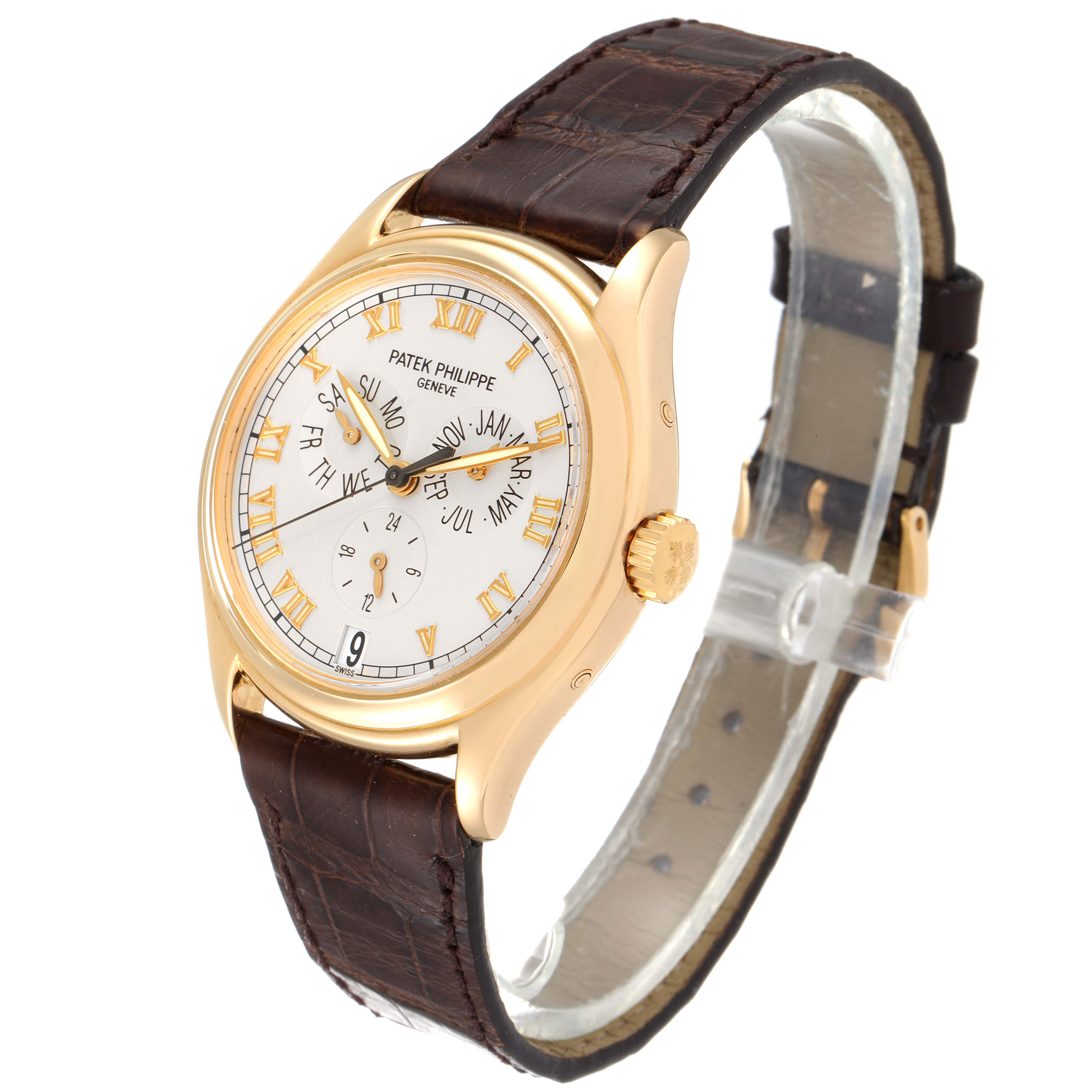 The image shows a side-angle view of the Patek Philippe Complications 5035G Men's Yellow Gold Silver Dial 5035G Men's Yellow Gold Silver Dial model, showcasing its face, crown, and brown leather strap.