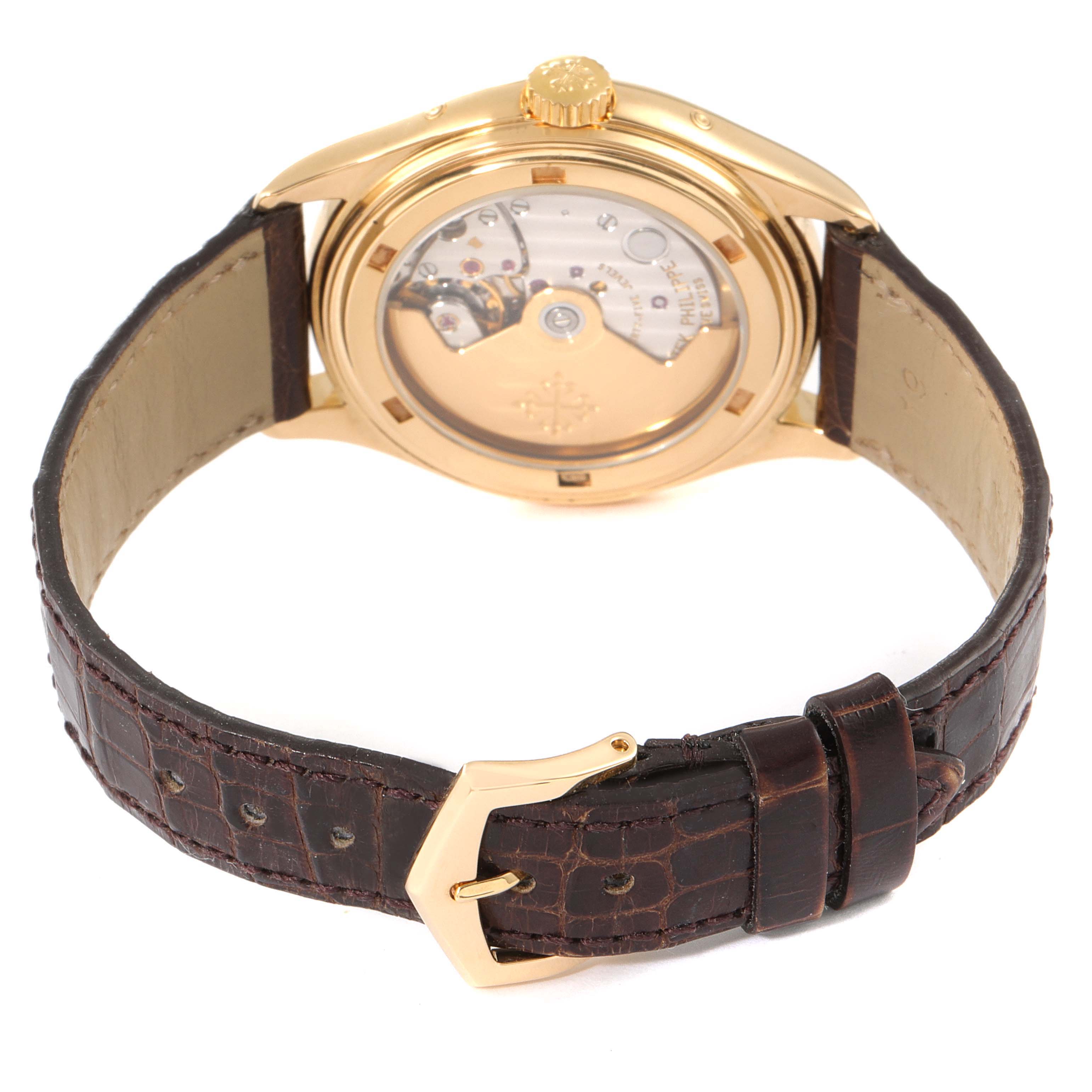 The image shows the back view of a Patek Philippe Complications 5035G Men's Yellow Gold Silver Dial 5035G Men's Yellow Gold Silver Dial watch, featuring its leather strap and transparent case back.