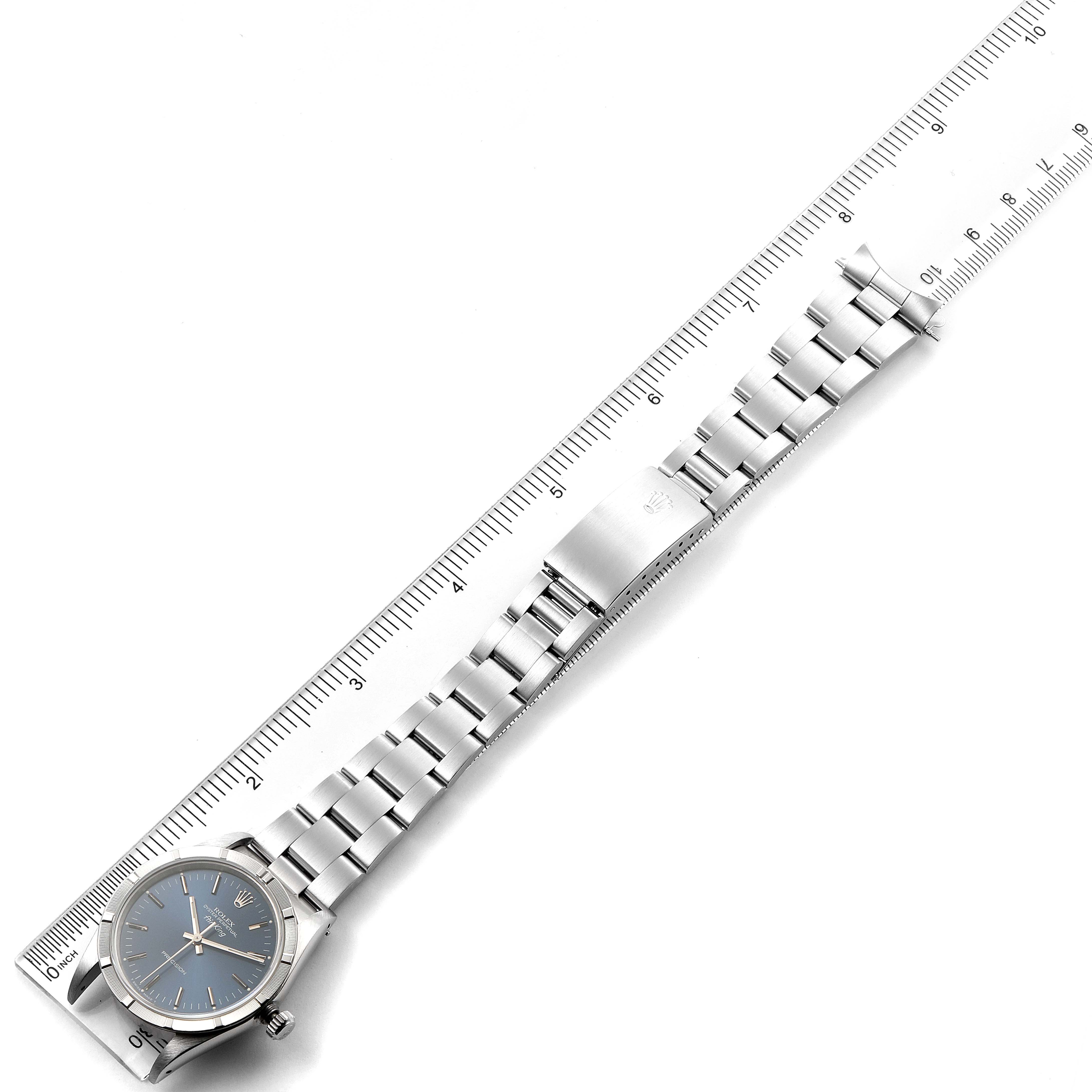 This image shows a top-down view of a Rolex Air-King 14010 Men's Stainless Steel Blue Dial 14010 Men's Stainless Steel Blue Dial watch on a ruler, displaying the face and bracelet.