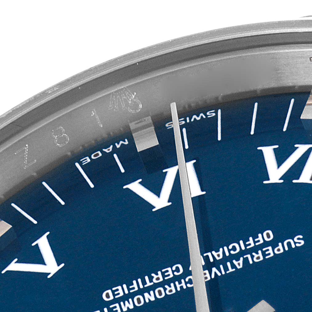 This close-up image of a Rolex Air-King 114210 Men's Stainless Steel Blue Dial 114210 Men's Stainless Steel Blue Dial watch shows part of the dial, including the Roman numeral VI and the second hand.
