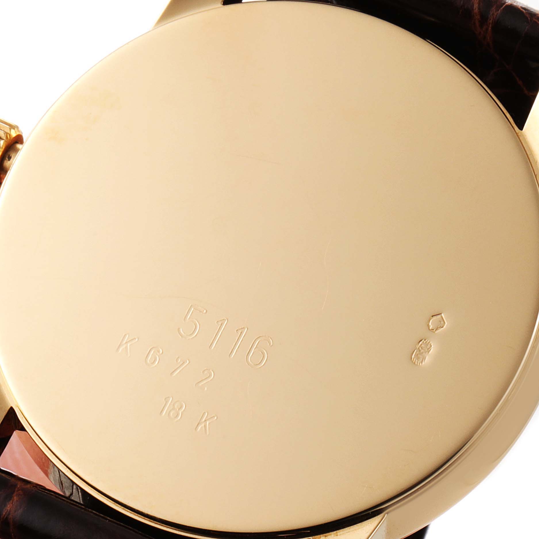 The image shows the case back of a Rolex Cellini 5116/8 Men's Yellow Gold Beige Dial 5116/8 Men's Yellow Gold Beige Dial model watch with engravings and part of the strap visible.